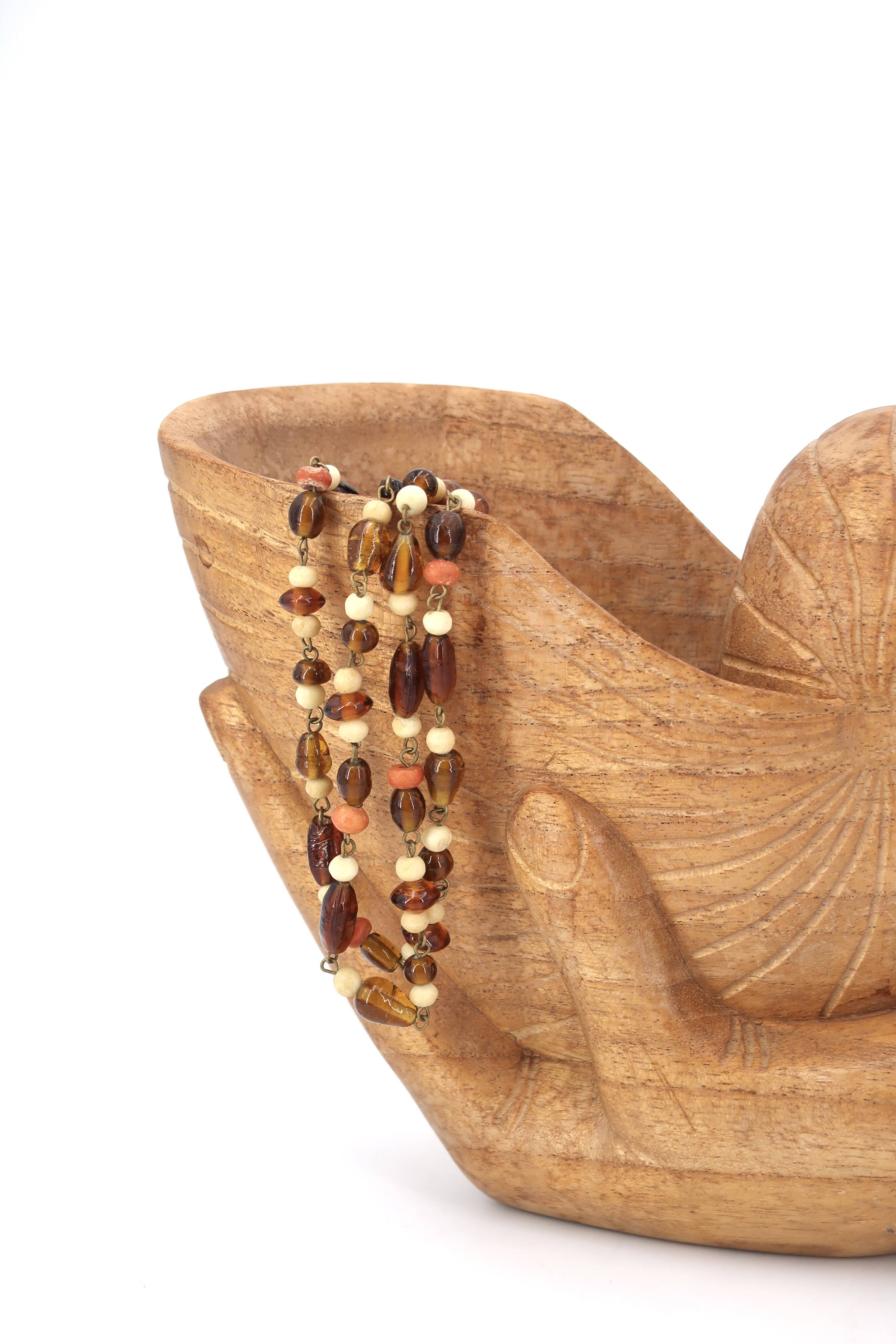 Wooden hand emptier holding a shell, 1970s