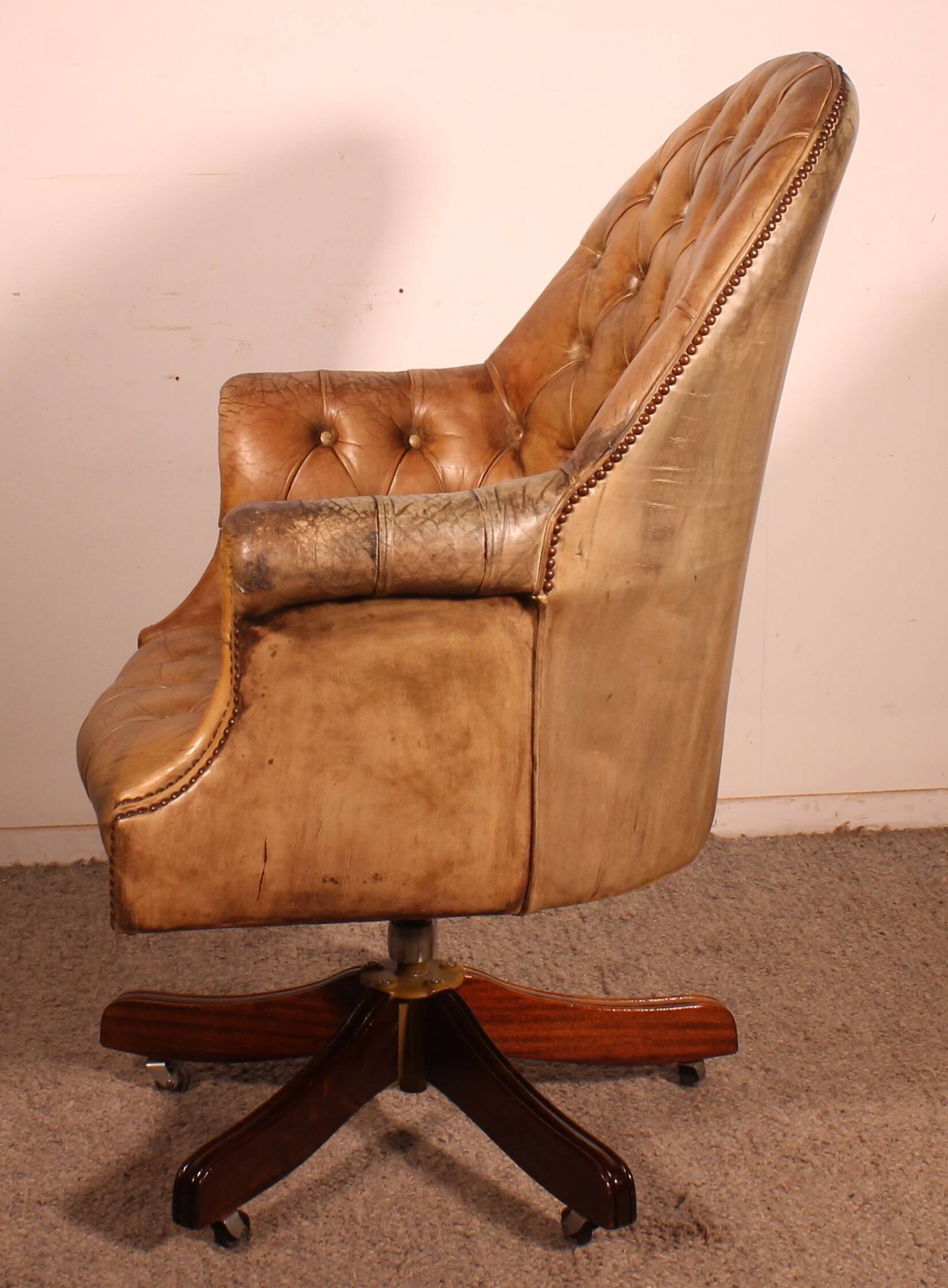 Office chair known as a presidential chair in mahogany and cognac leather.