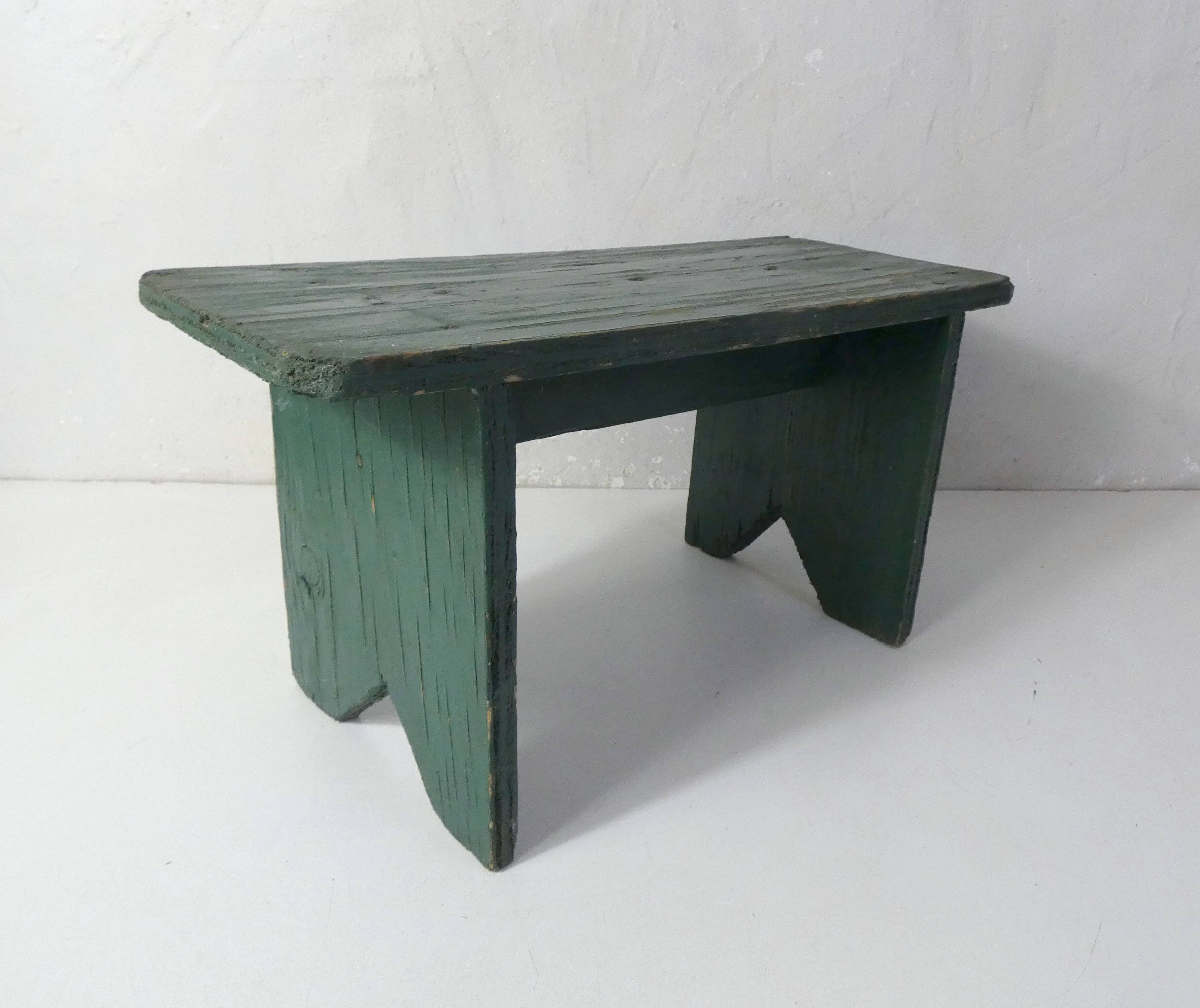 Old small wooden bench with green foot