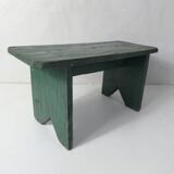 Old small wooden bench with green foot