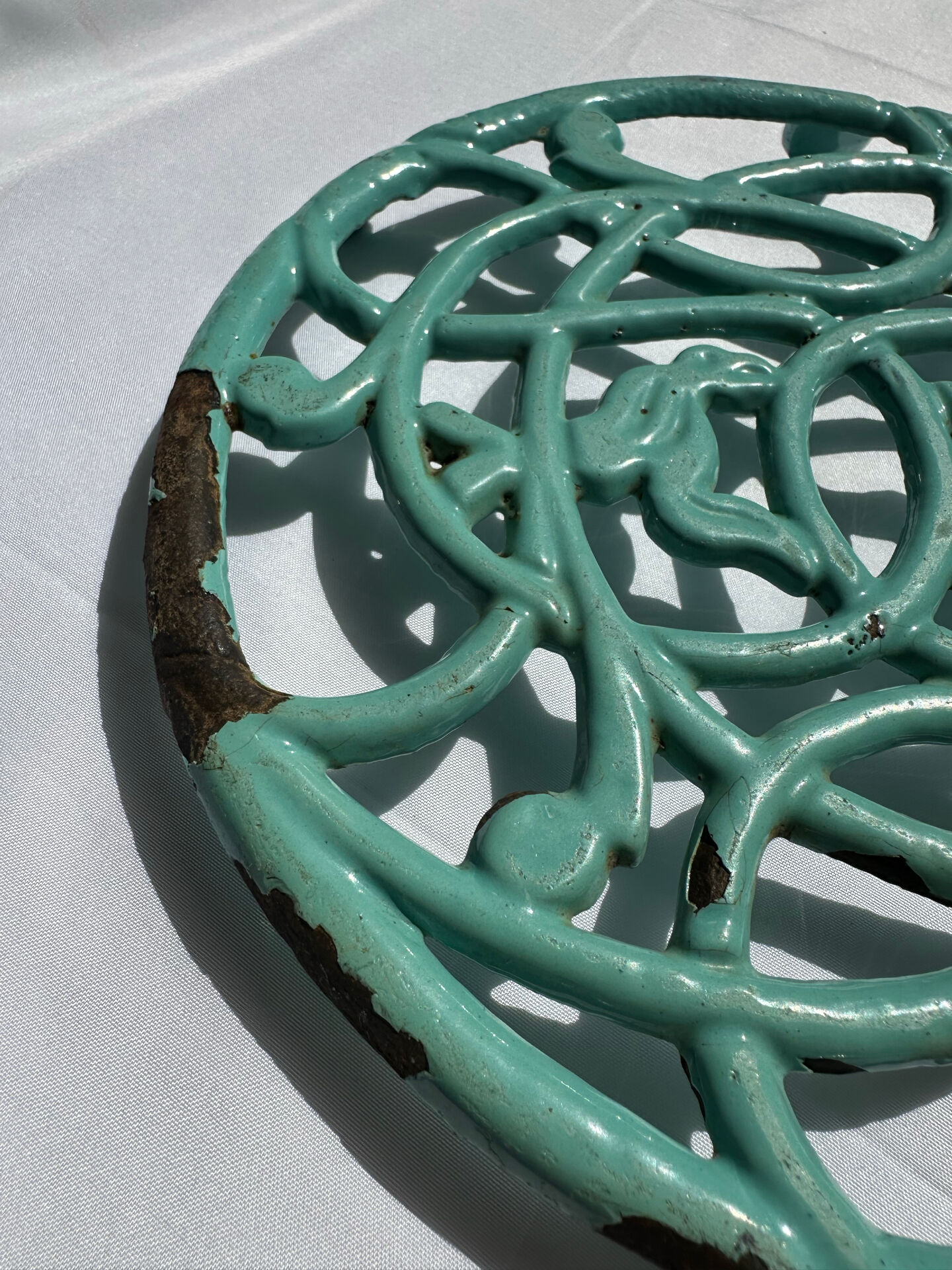 Enamelled cast iron trivet in blue with wrought iron decoration.