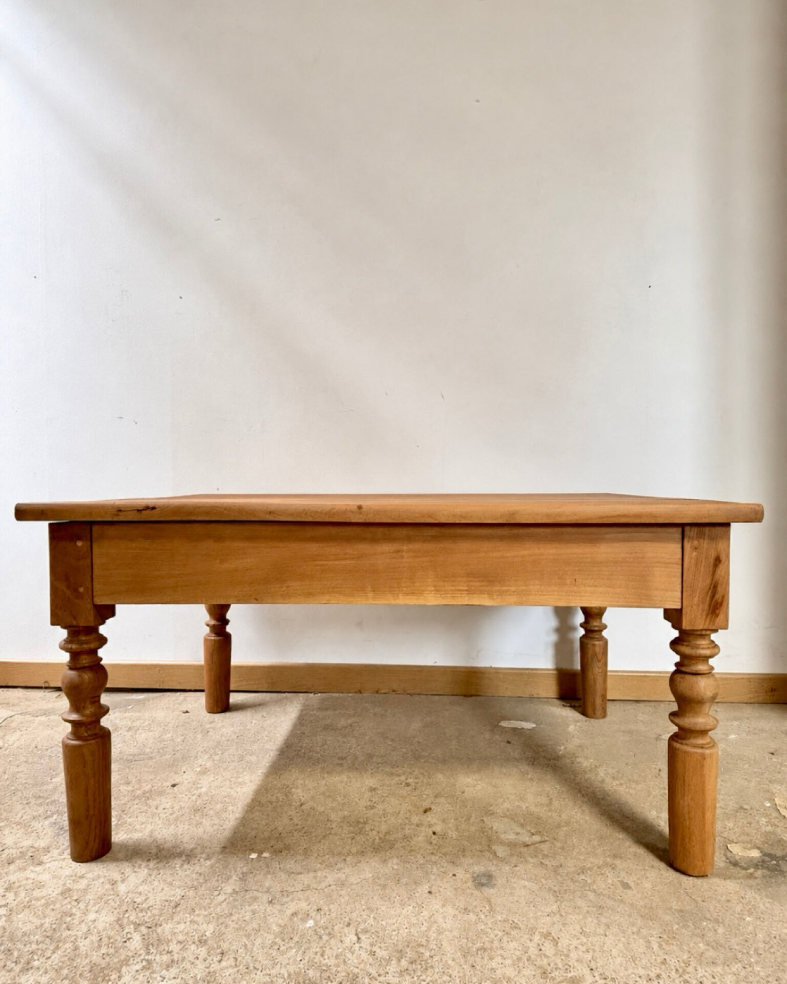 Antique coffee table in solid elm with turned legs.