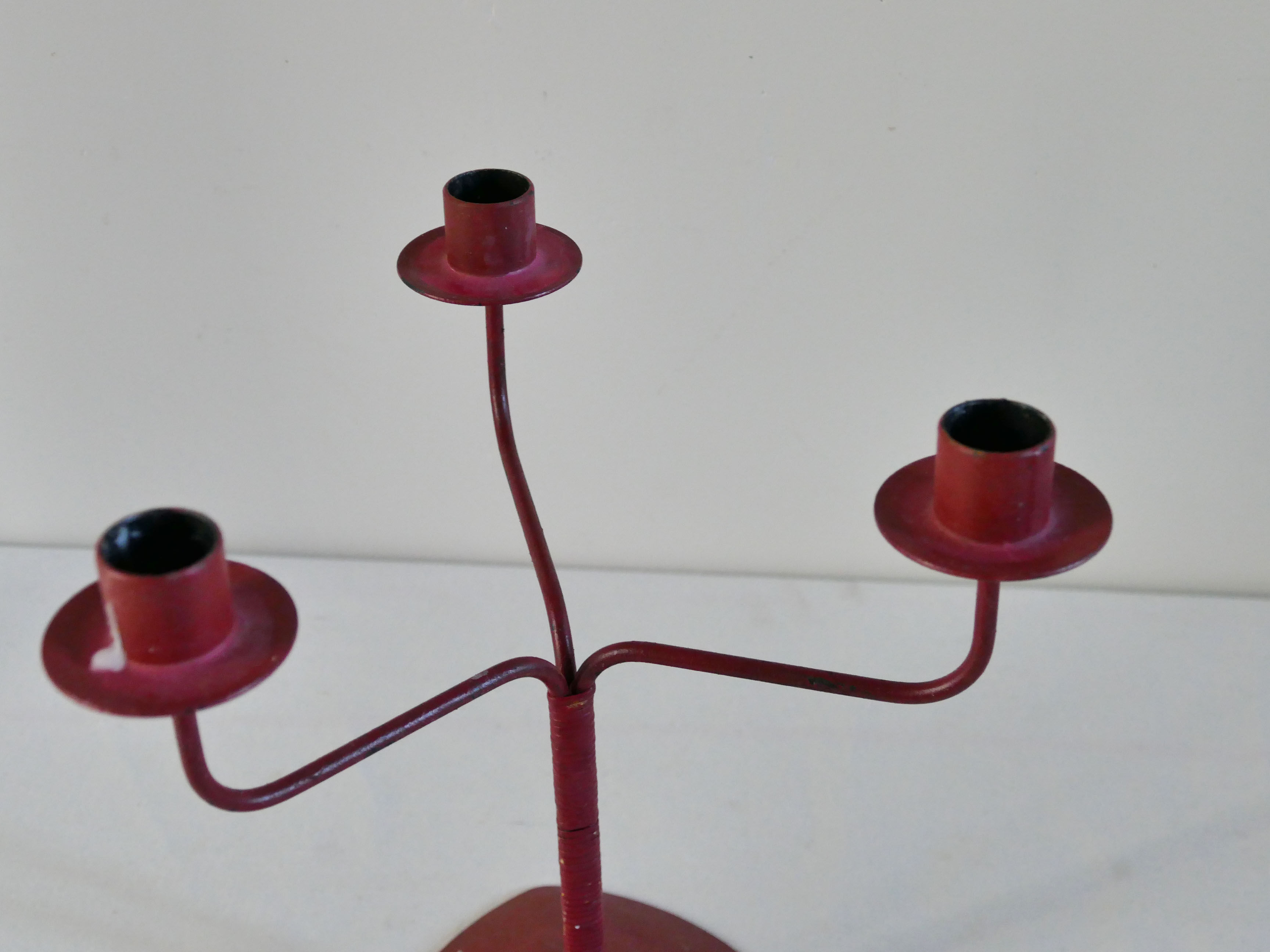 Red metal chandelier for three candles