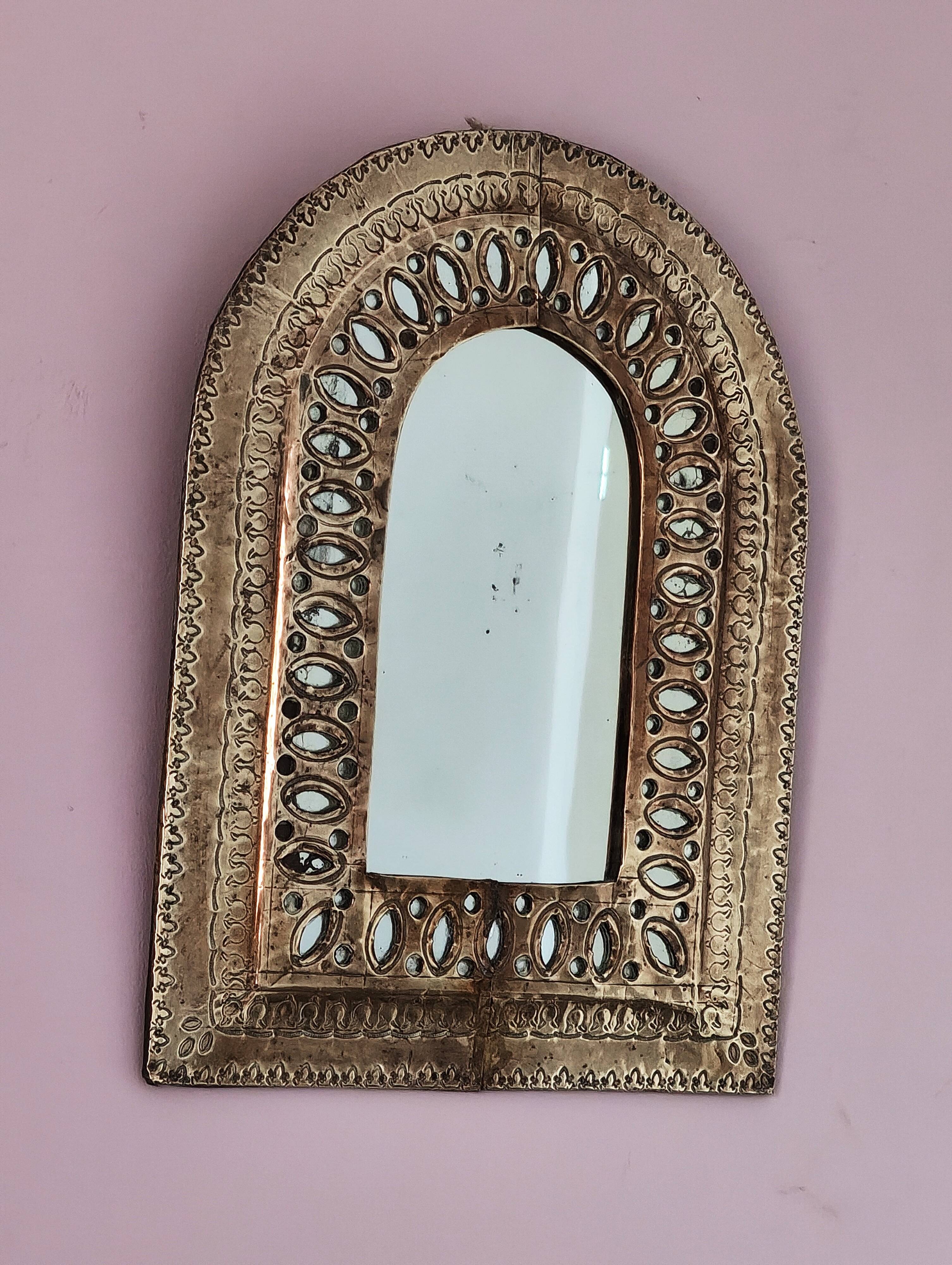 Small golden metal mirror in oriental style.