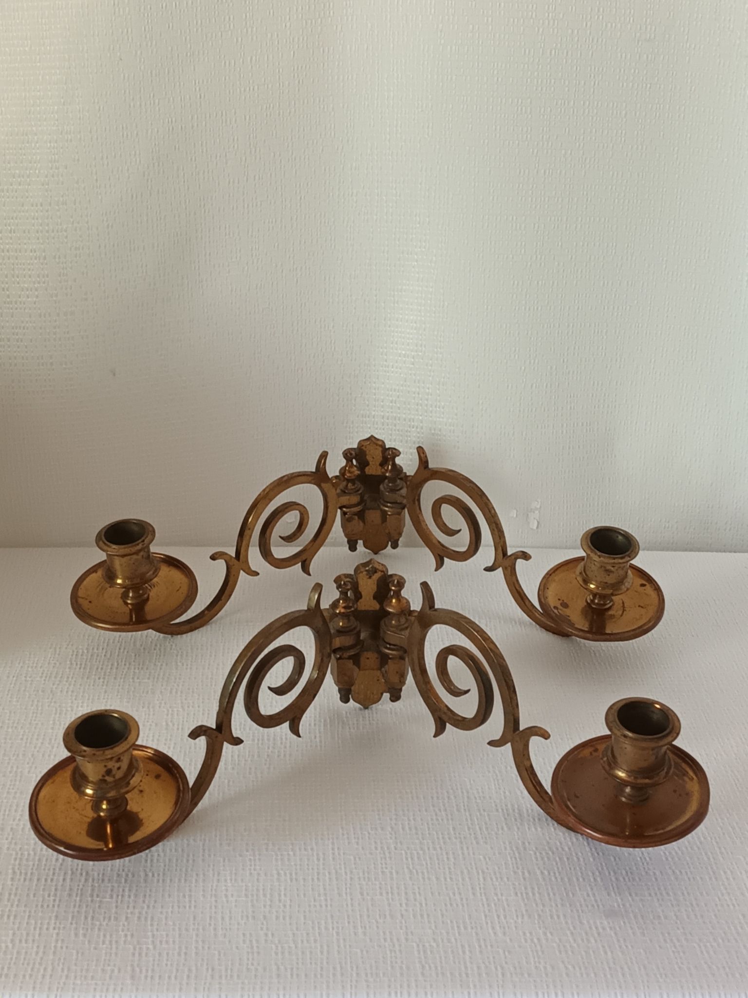 Pair of antique wall-mounted brass candle holders