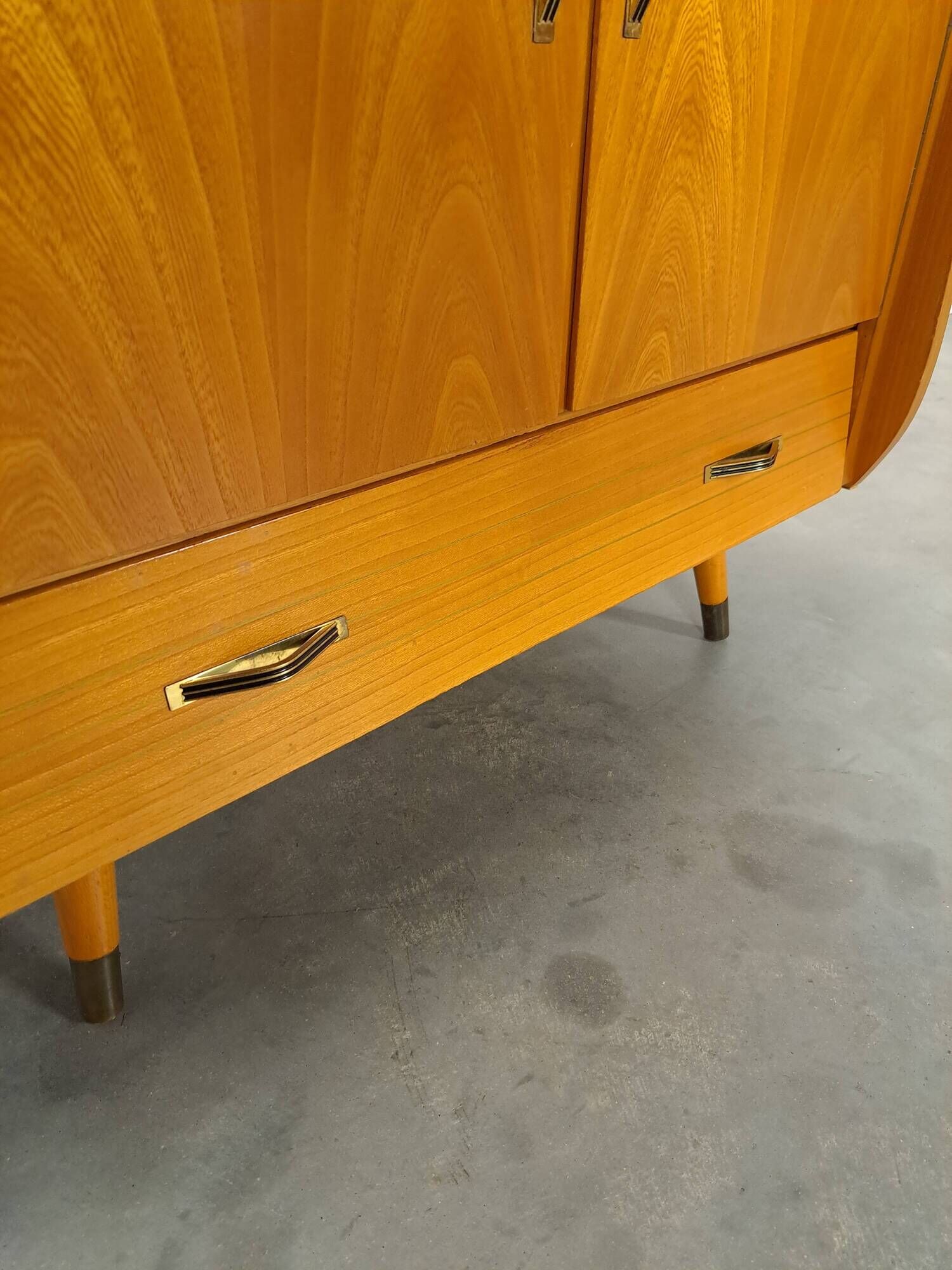 Meuble TV audio avec poignées en laiton et pieds inclinés.