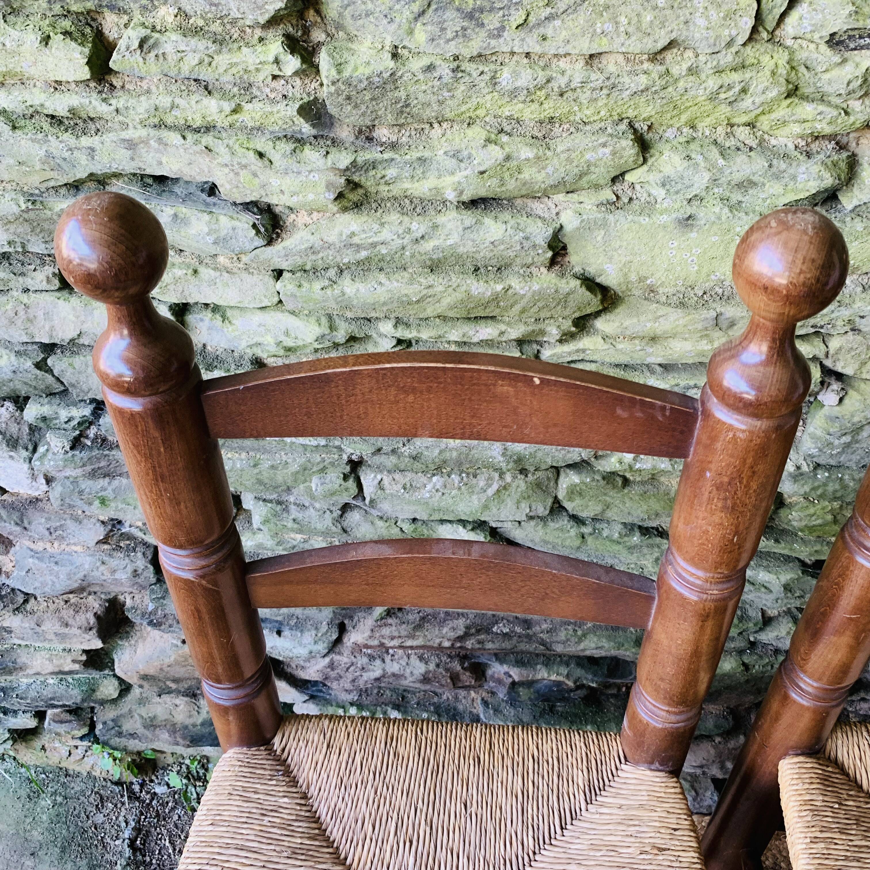 Set of 4 solid wood chairs with straw seats.