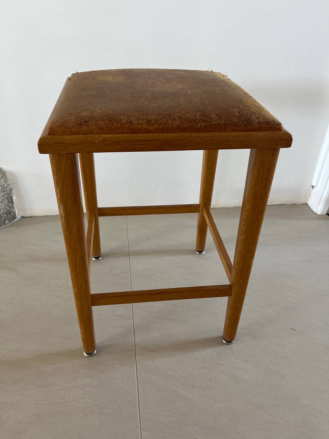 Vintage stool from the 60s with aged leather seat