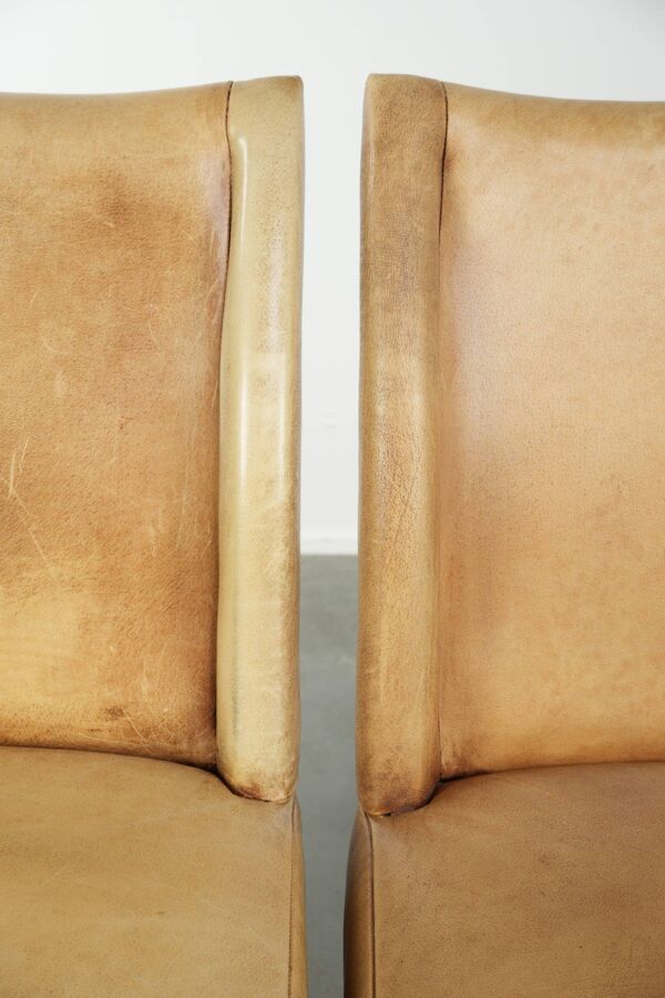 Ensemble de six chaises de salle à manger en cuir de vache avec un siège confortable et un dossier haut.
