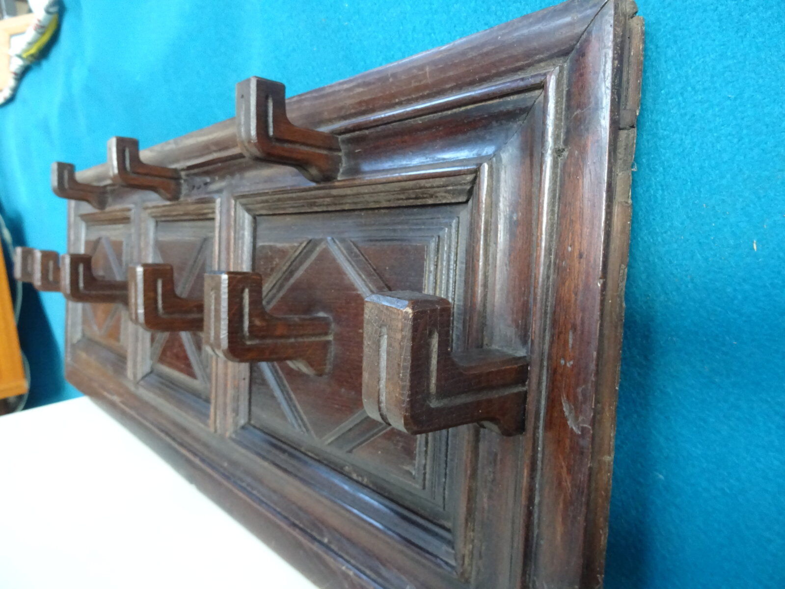 Wall-mounted coat rack in solid oak with 9 hooks.