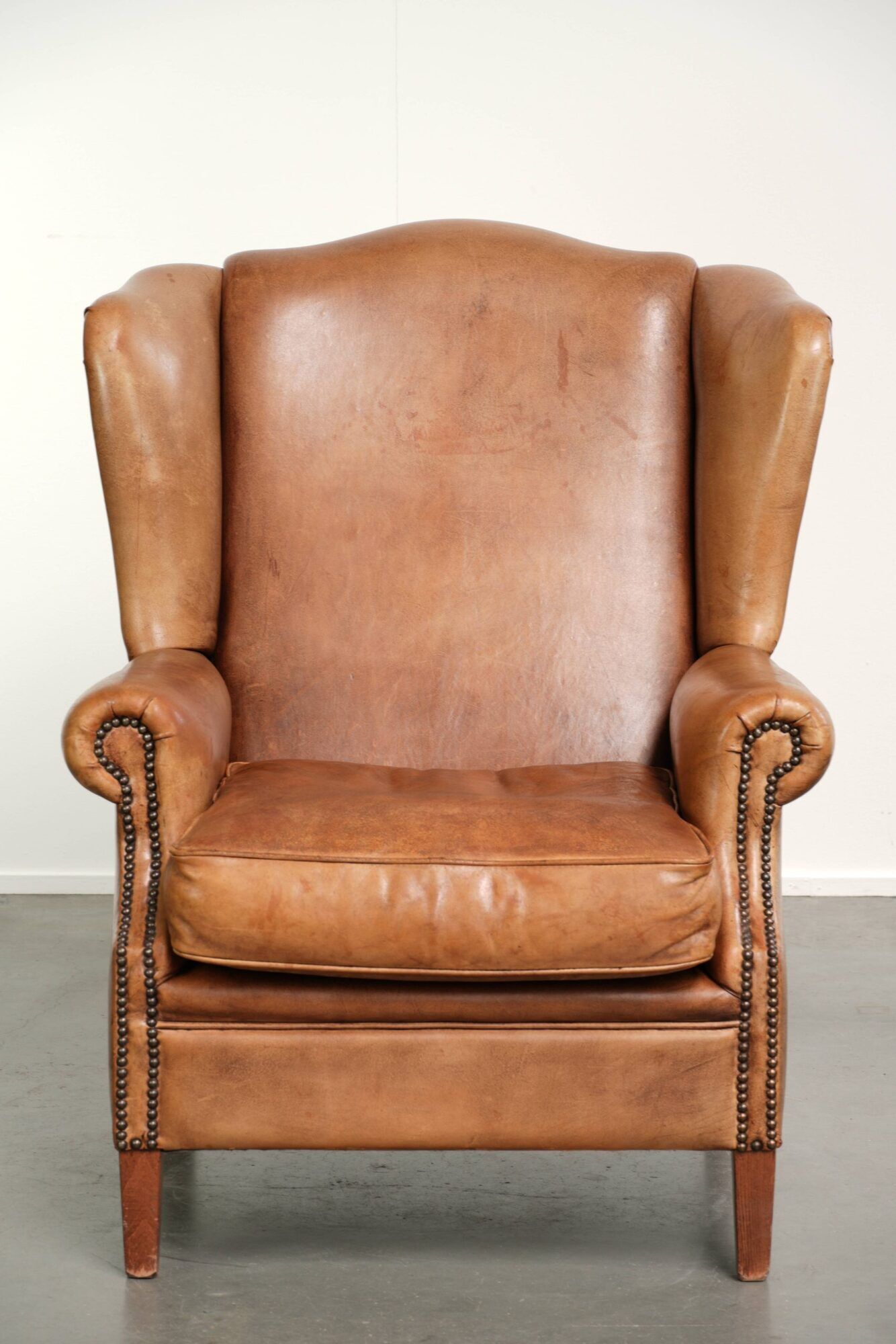 Sheepskin wingback armchair in a light cognac colour in English style