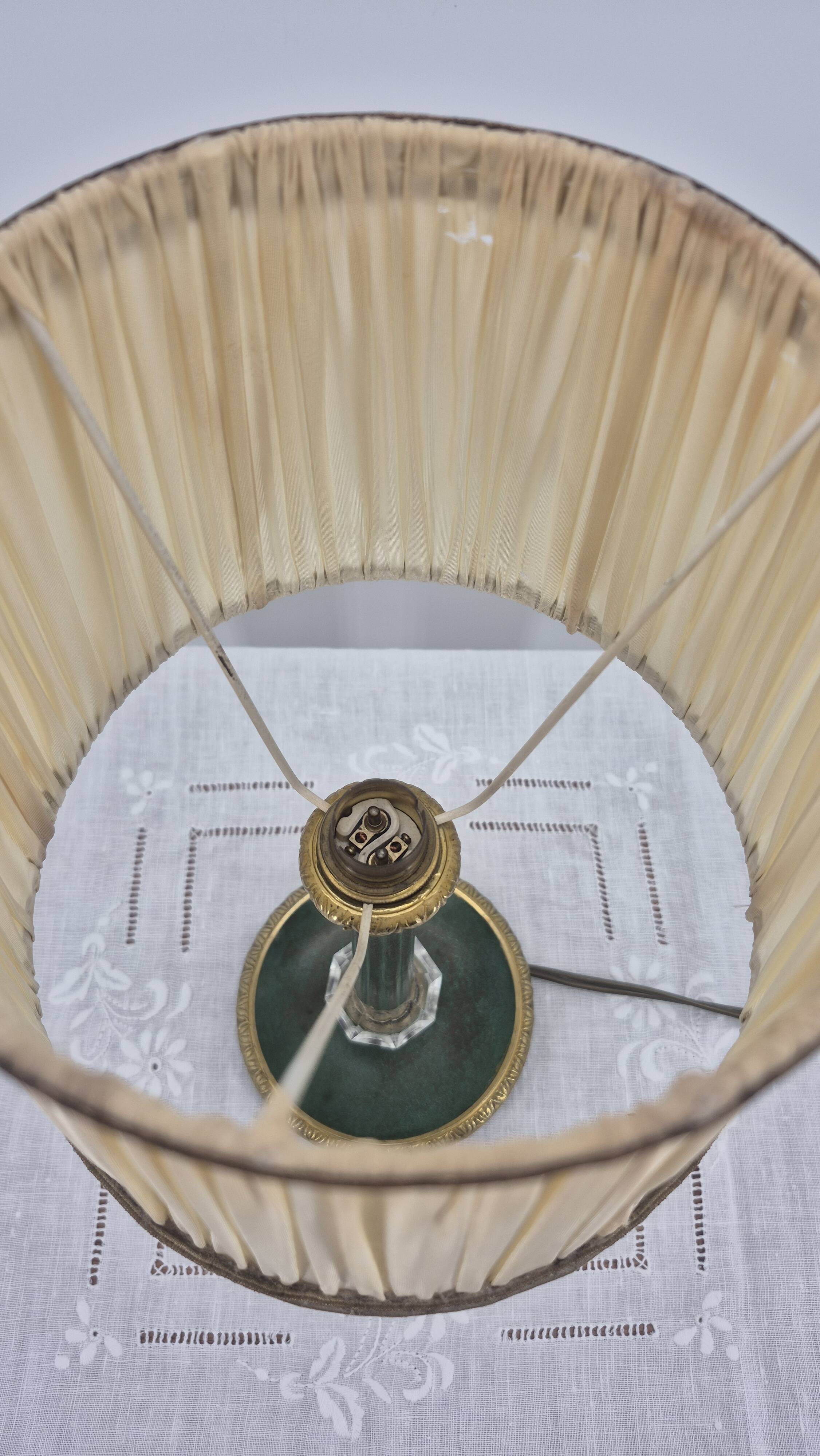 Brass table lamp with green patina and empire-style fabric shade.