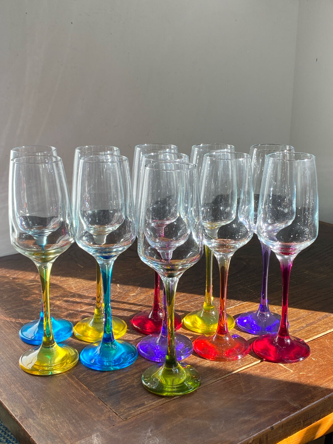Champagne coupes in glass, multicoloured stems.