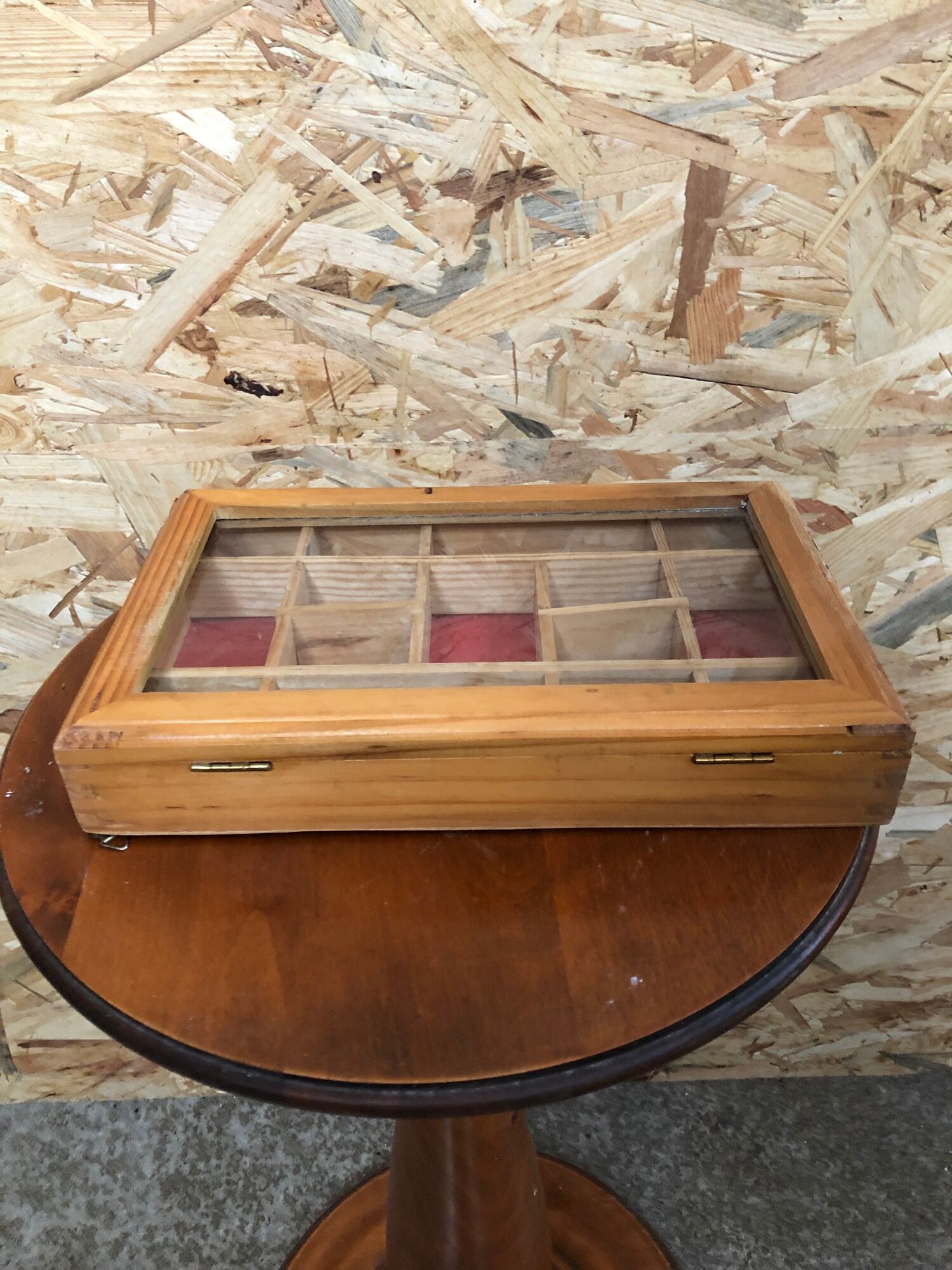 Old hanging display case with 15 wooden boxes, red background + vintage glass door