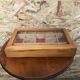 Old hanging display case with 15 wooden boxes, red background + vintage glass door