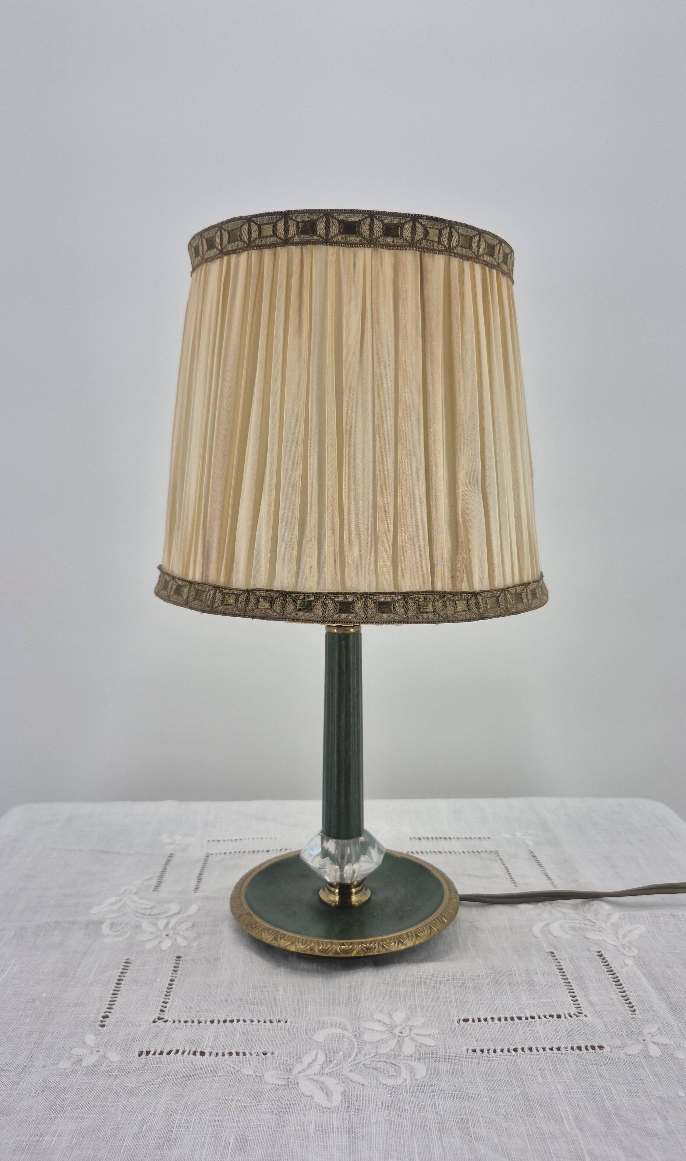 Brass table lamp with green patina and empire-style fabric shade.
