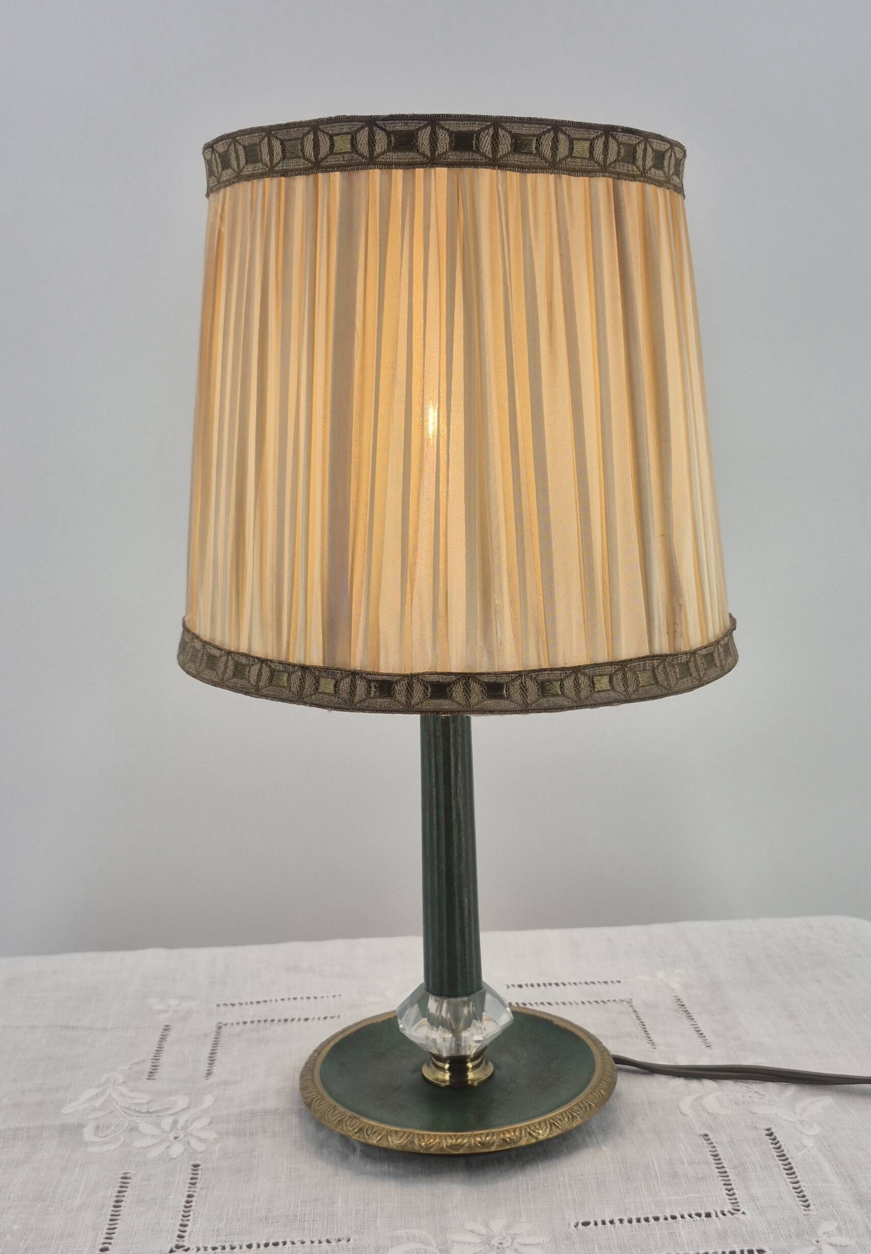 Brass table lamp with green patina and empire-style fabric shade.