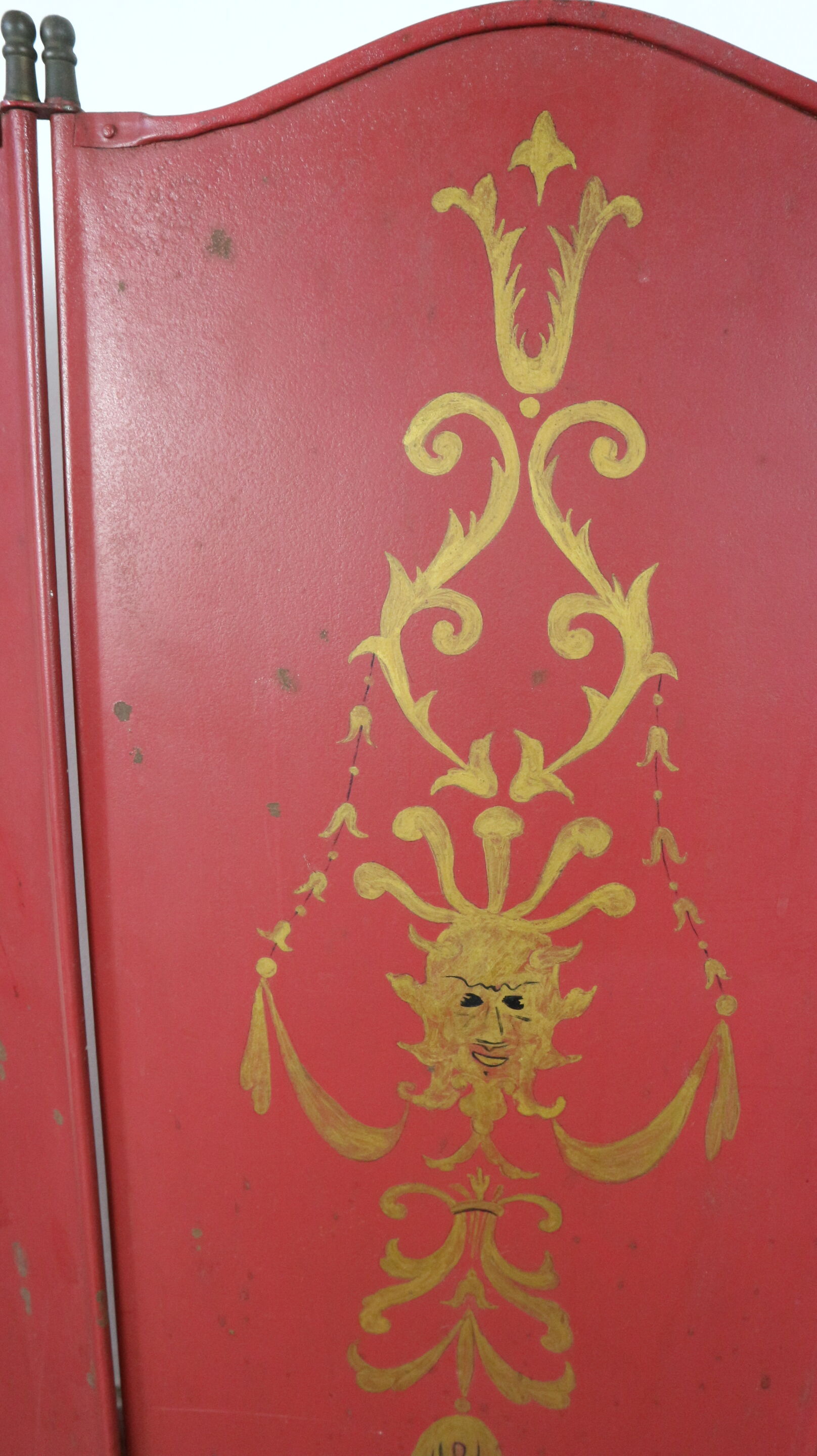 Pare-feu peint en rouge avec des décorations peintes en or