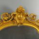 Large antique gilded wooden mirror in Louis XVI style with a sculpted pediment, 19th century.