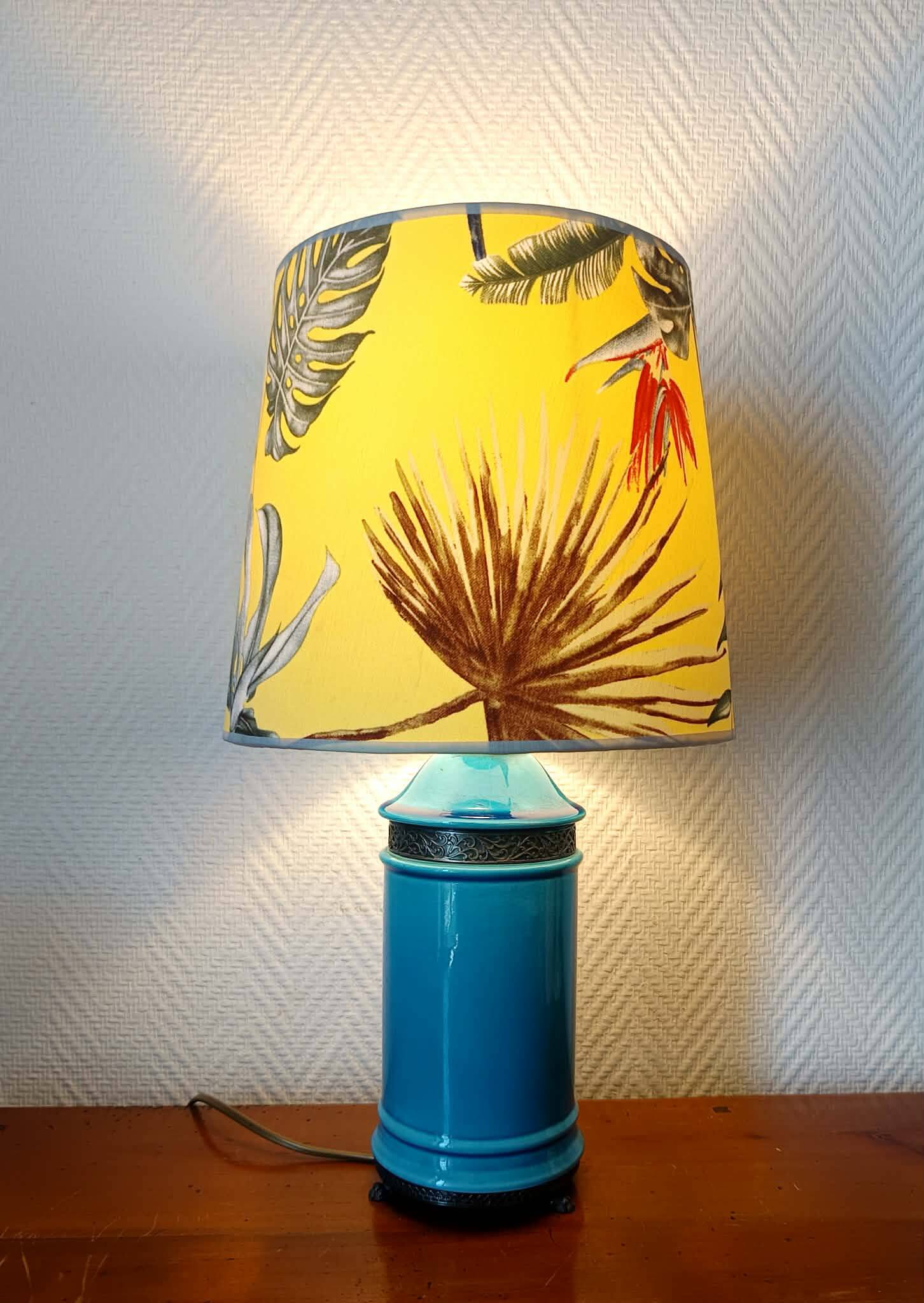 Blue ceramic lamp with claw feet and foliage lampshade.