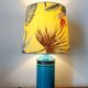 Blue ceramic lamp with claw feet and foliage lampshade.