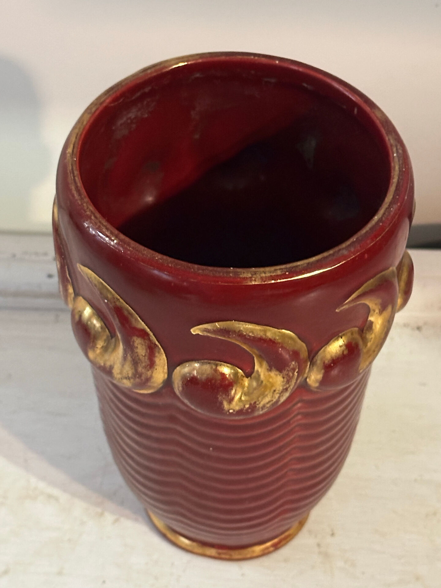 Mid-century relief vase in ruby red enhanced with gilding.