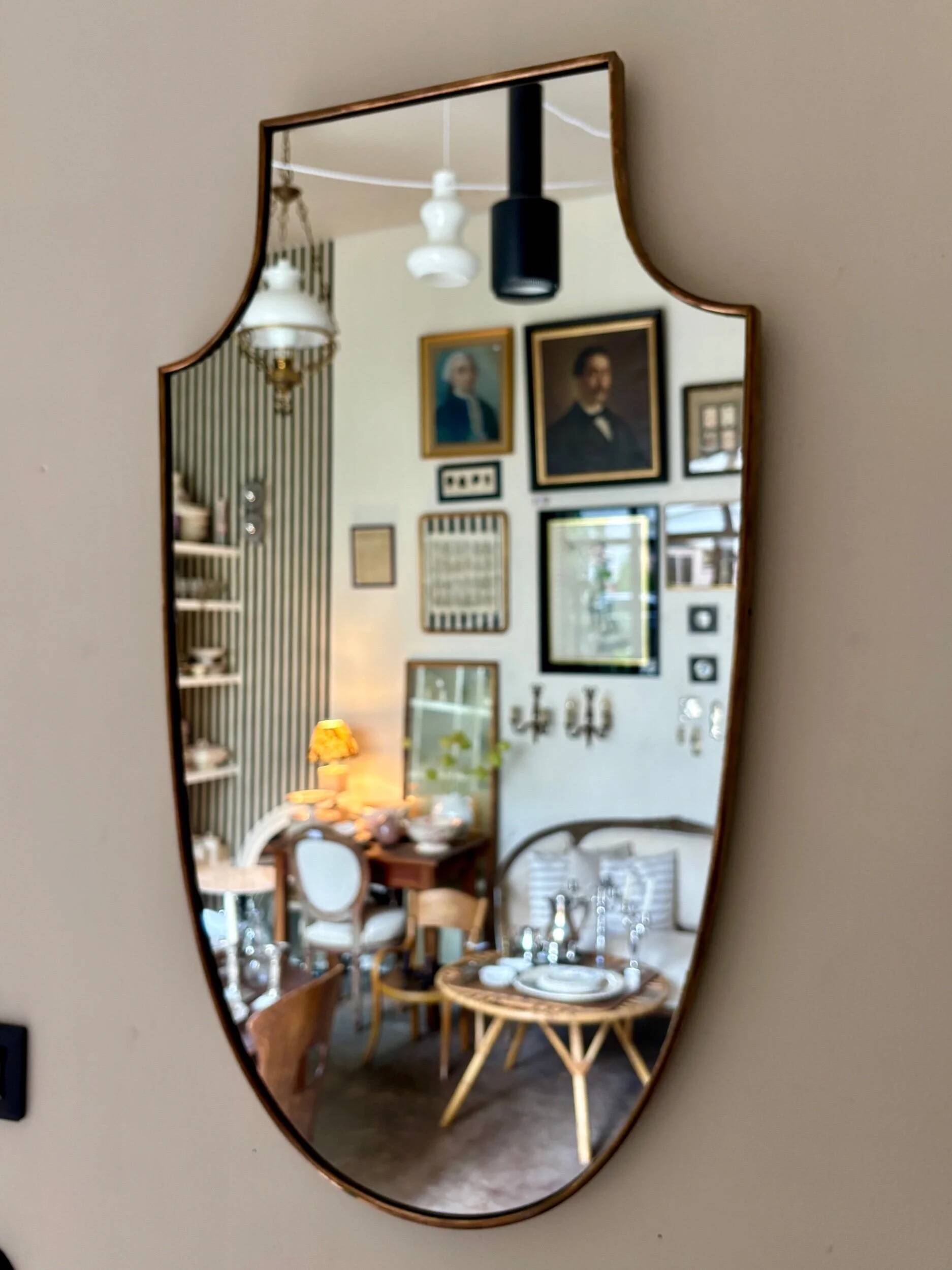 Miroir "écusson" avec cadre en métal doré 86 x 50 cm