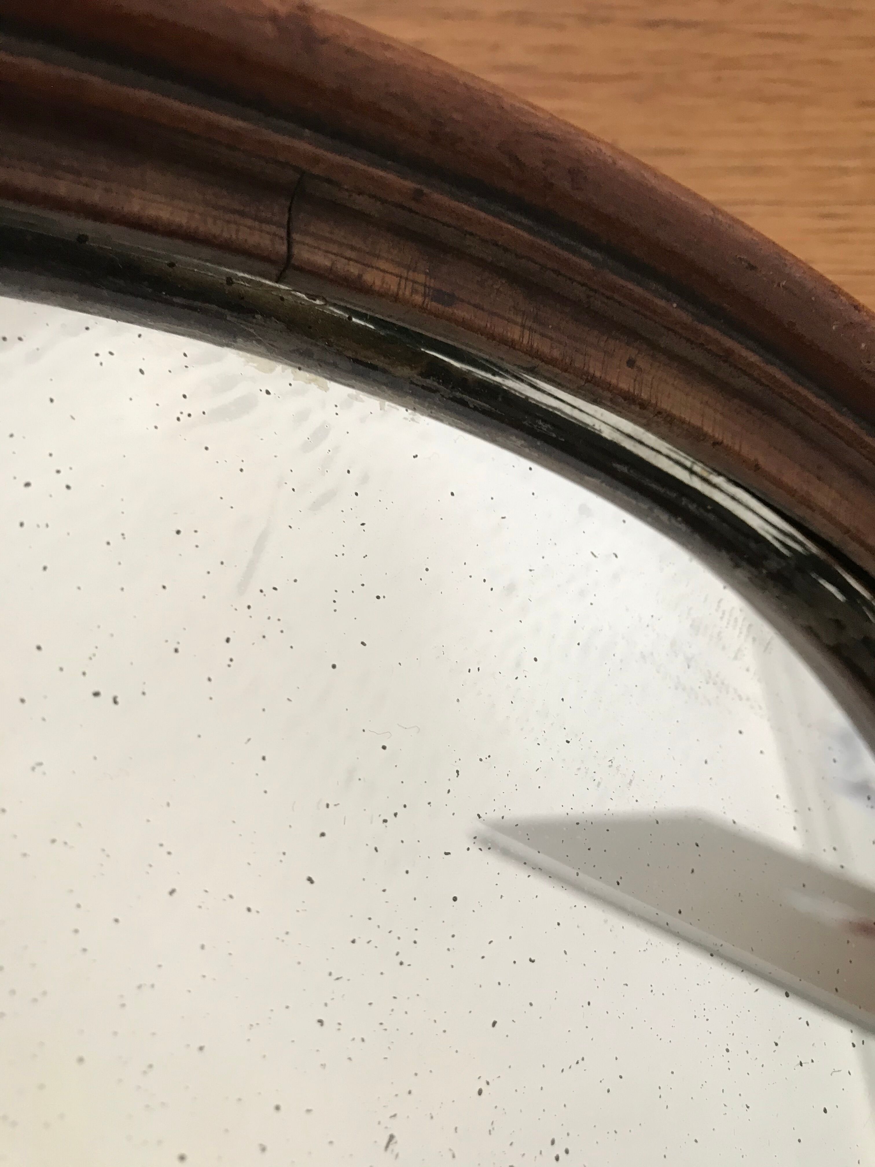 Old oval mirror with wooden frame