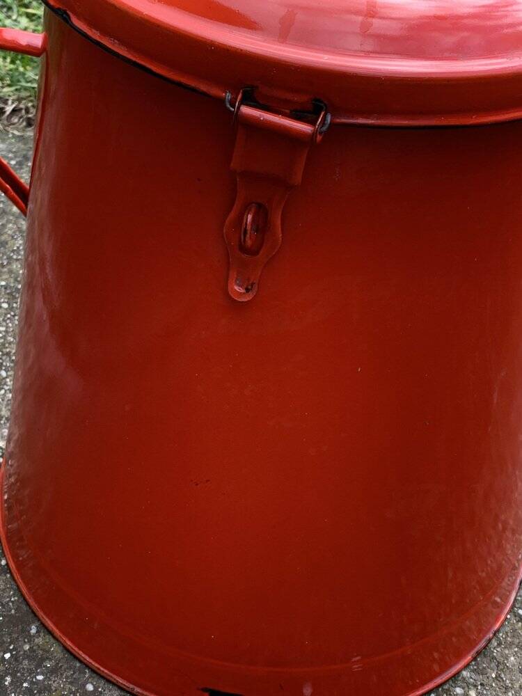 Red enamelled metal bin from the 1950s, with a lockable lid and side handles.