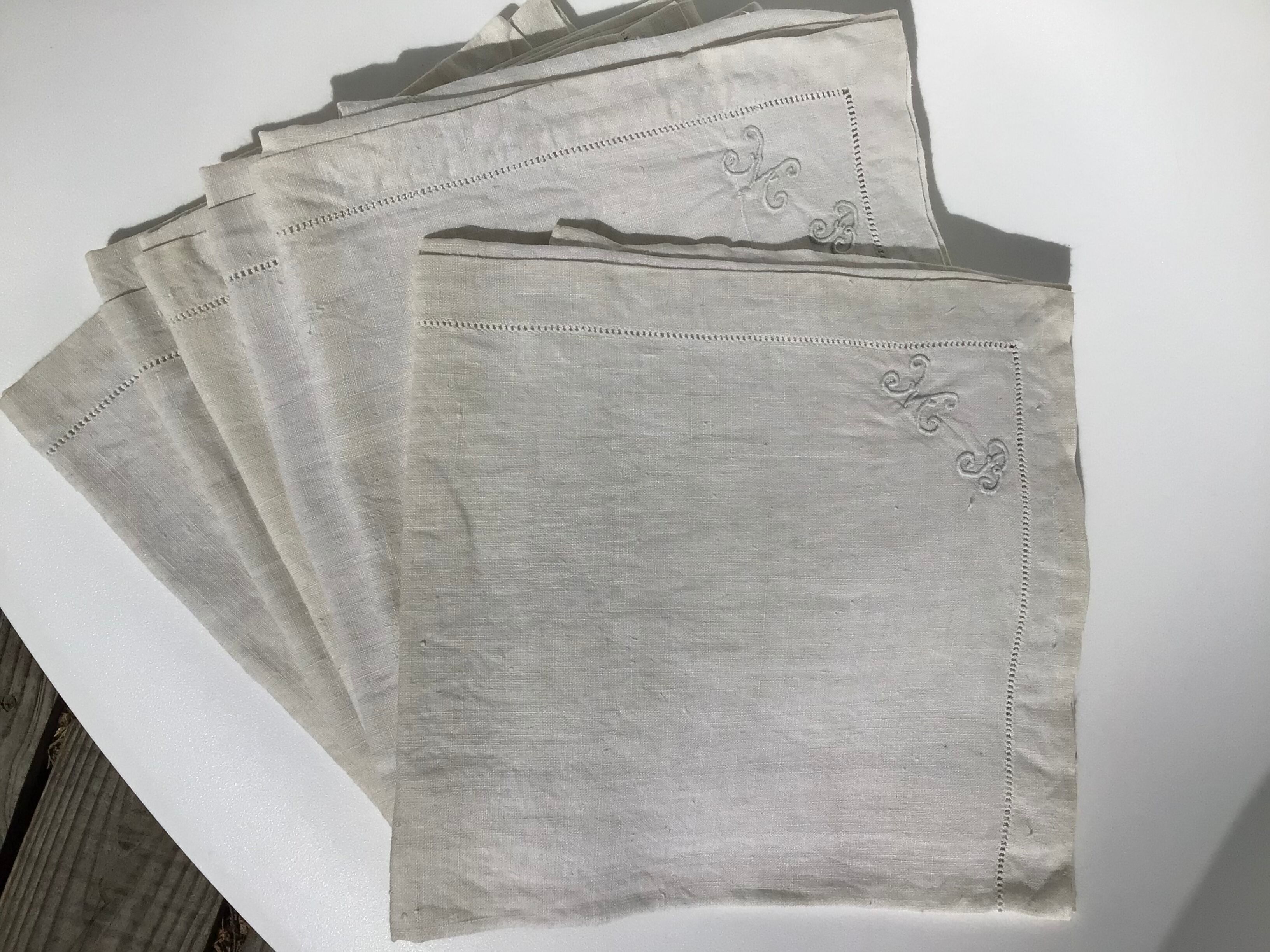 6 square linen napkins with hand-embroidered initials in the corner.