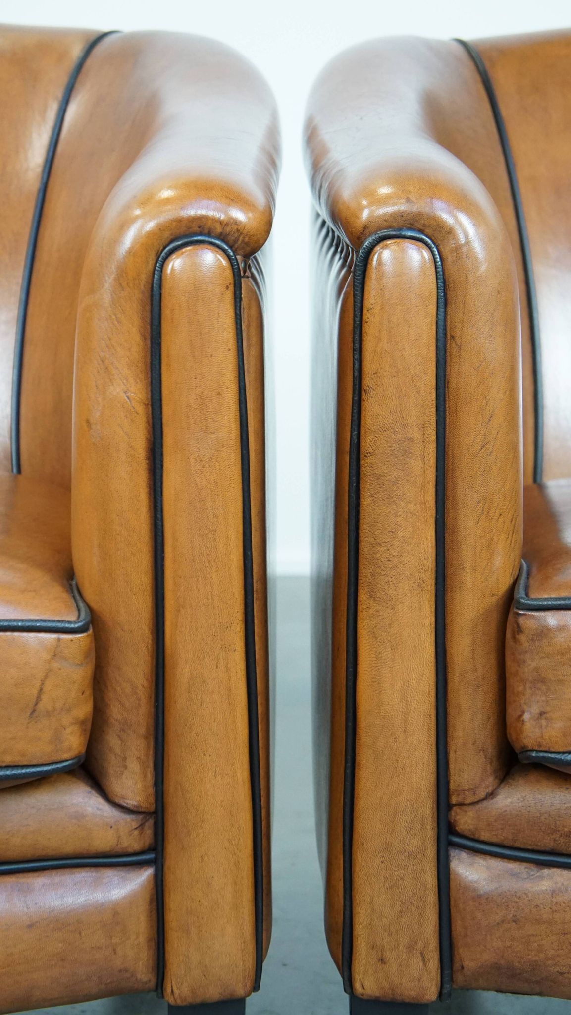 Set of 2 sheep leather club chairs finished with black piping
