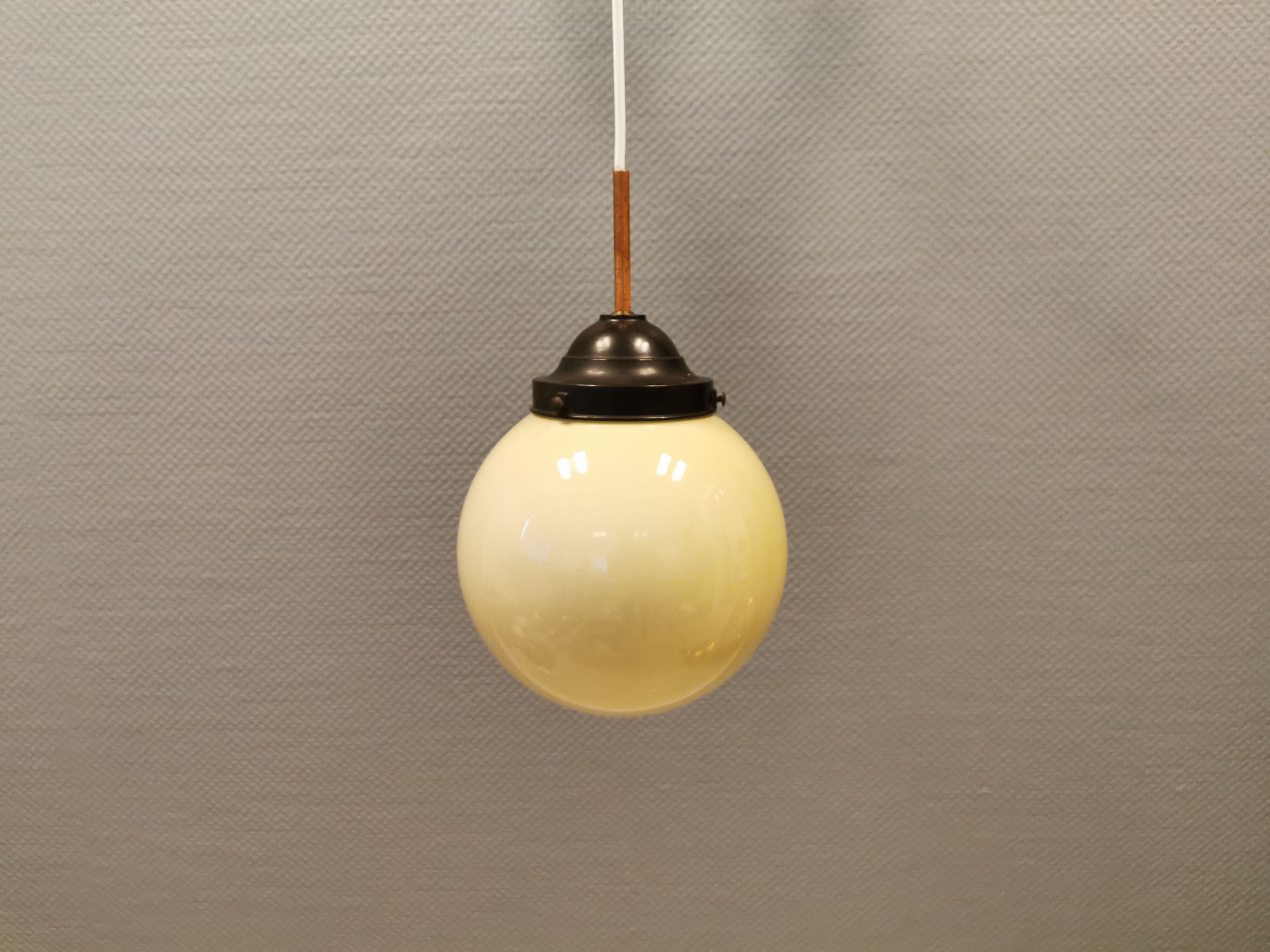 Small Art Deco hanging lamp in cream coloured glass and bakelite top.