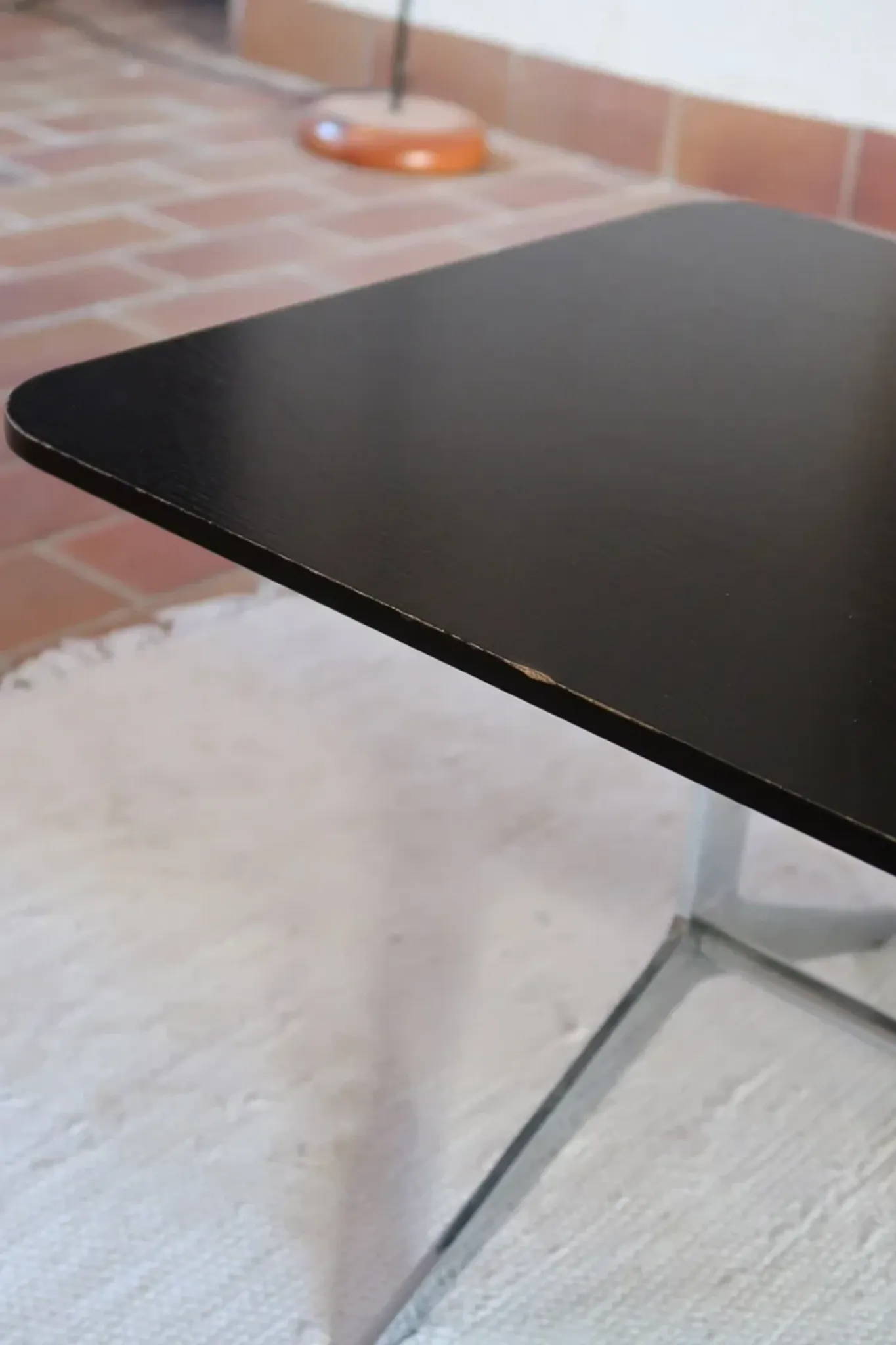70s design coffee table with a black top and steel legs.