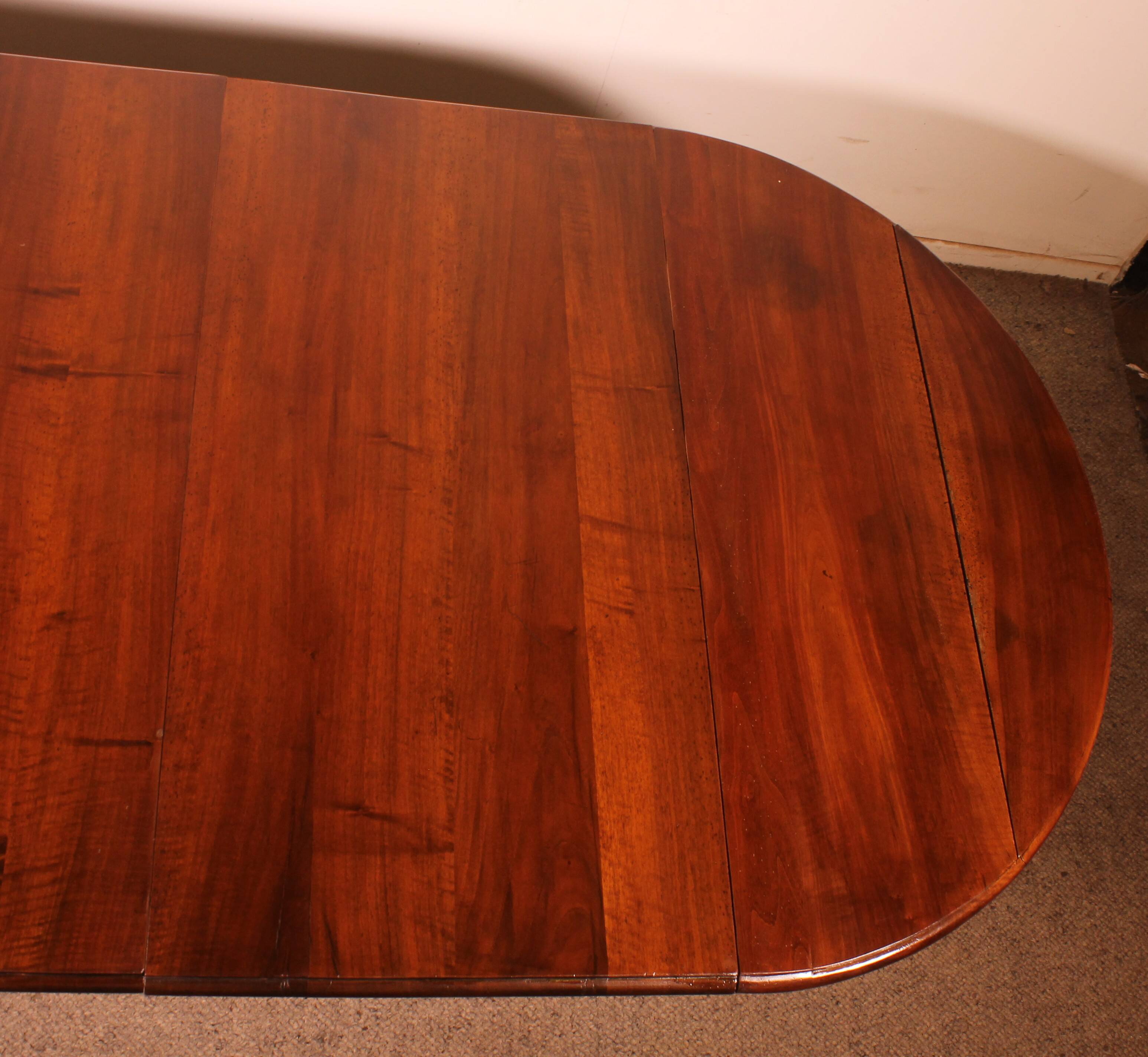 Extensible dining table from the early 19th century in walnut.