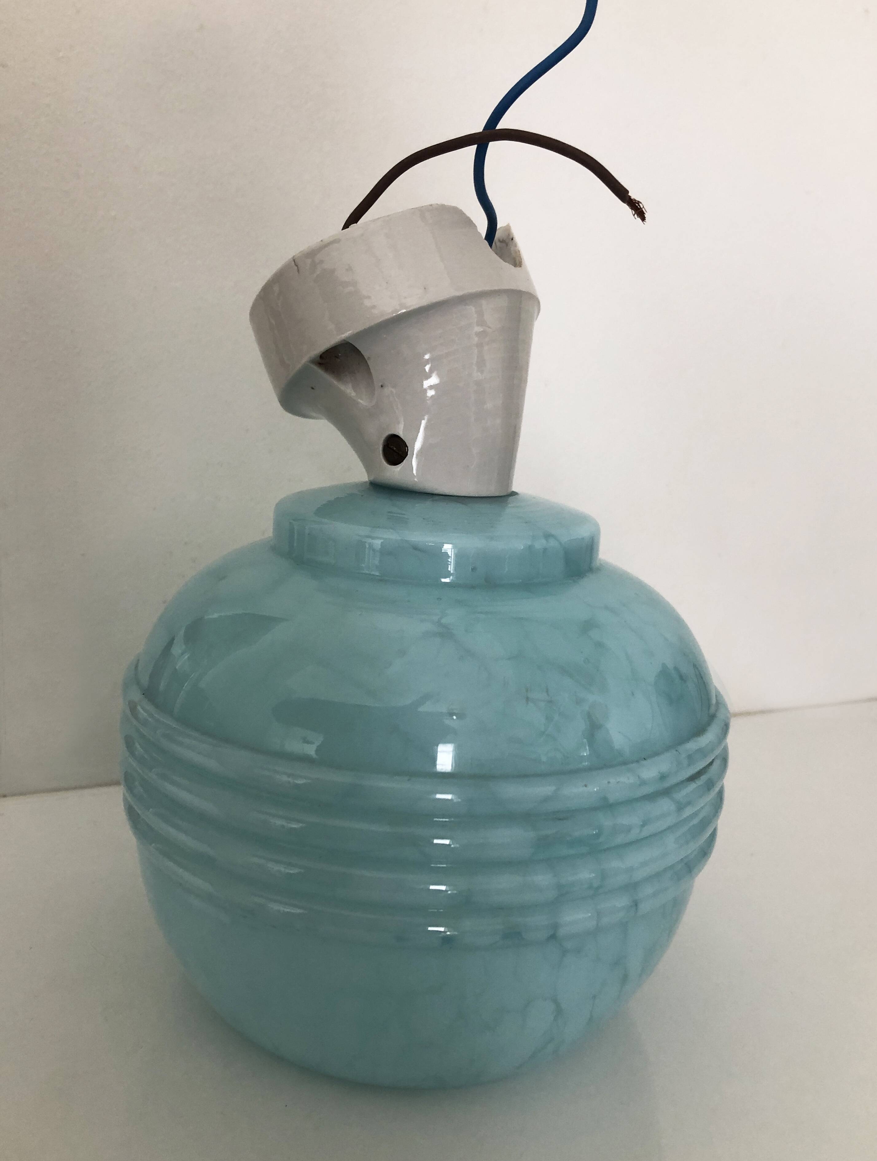 Wall light in ceramic with a light blue glass globe.
