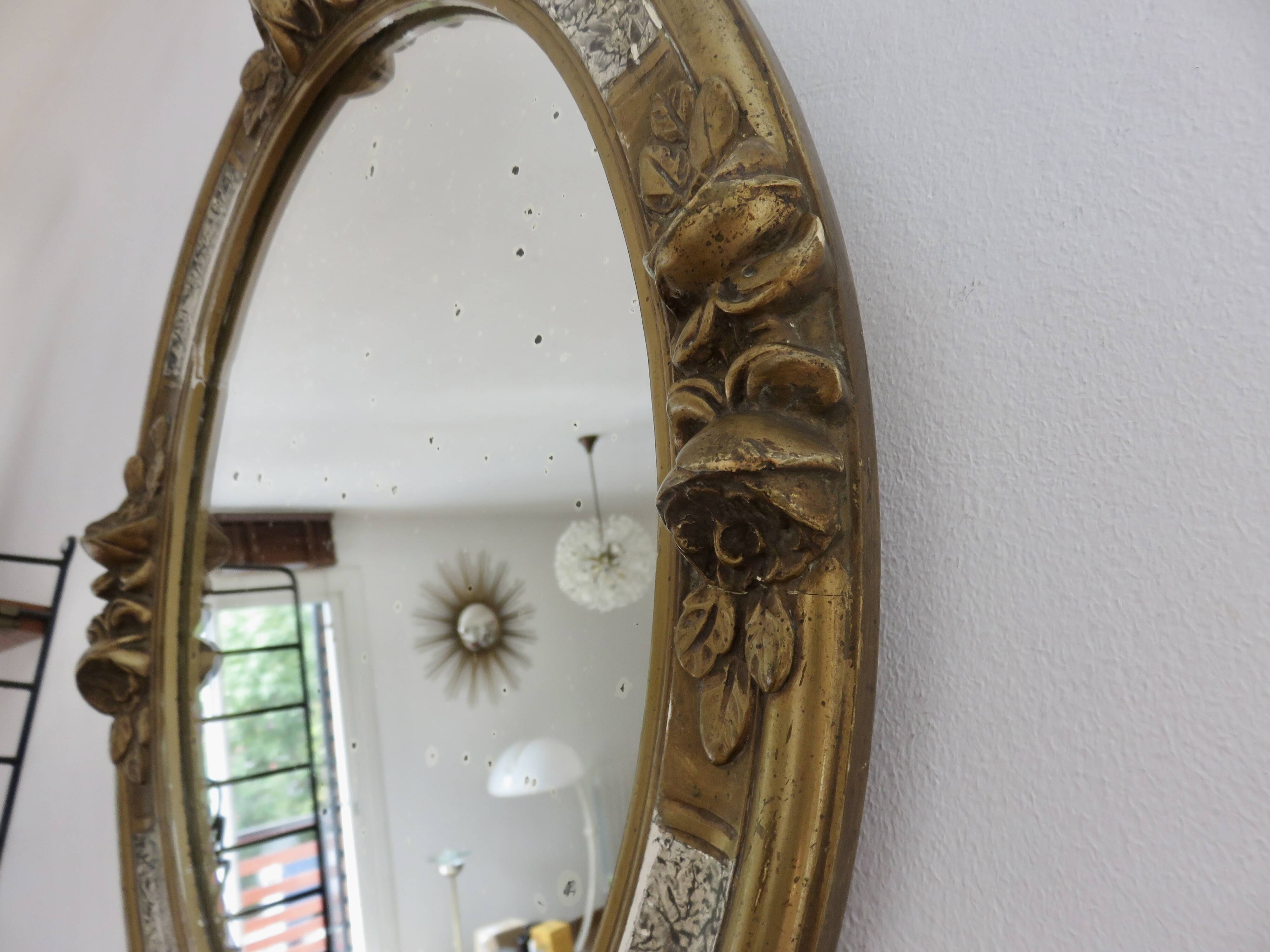 Oval wall mirror, golden floral pattern in stucco and wood, late 19th century