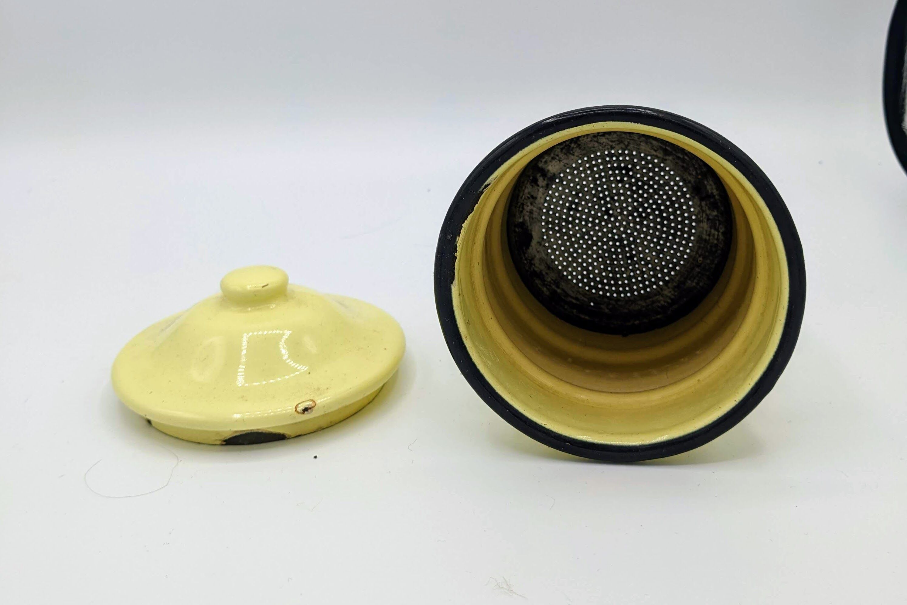 Old coffee maker in pastel yellow and black enamelled sheet metal