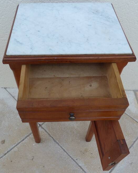 Antique bedside table with its marble top and white earthenware interior