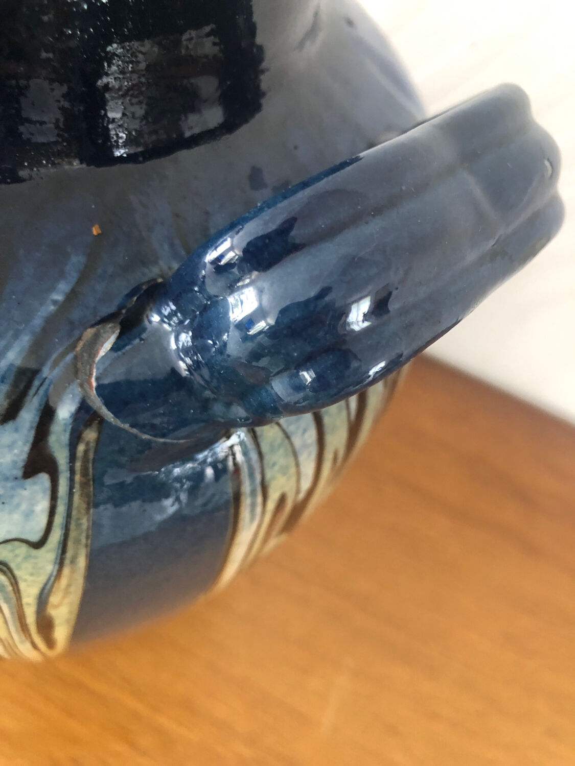 Vase in glazed ceramic decoration drips on blue background