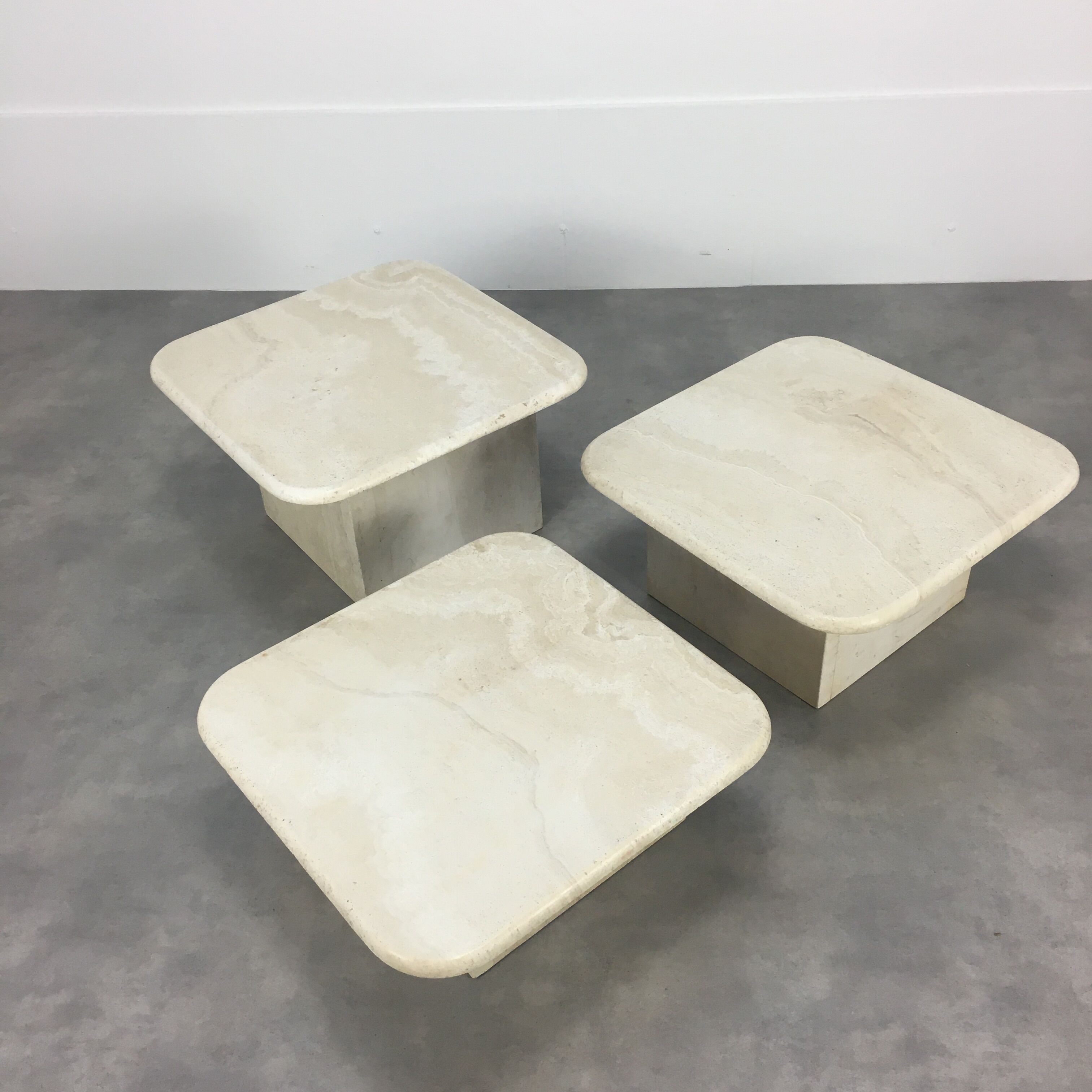 Three travertine trundle coffee tables