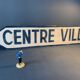 Panneau de signalisation vintage, en bois peint, centre ville.