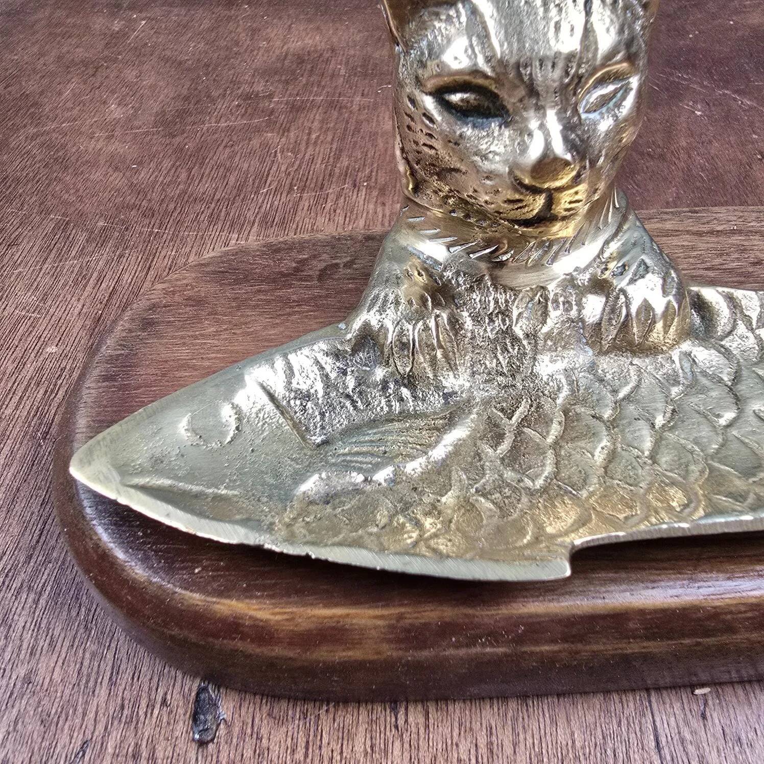 Vintage cat fish catchall in brass on a solid wood base.