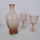 Old bottle in pink glass and 2 wine glasses