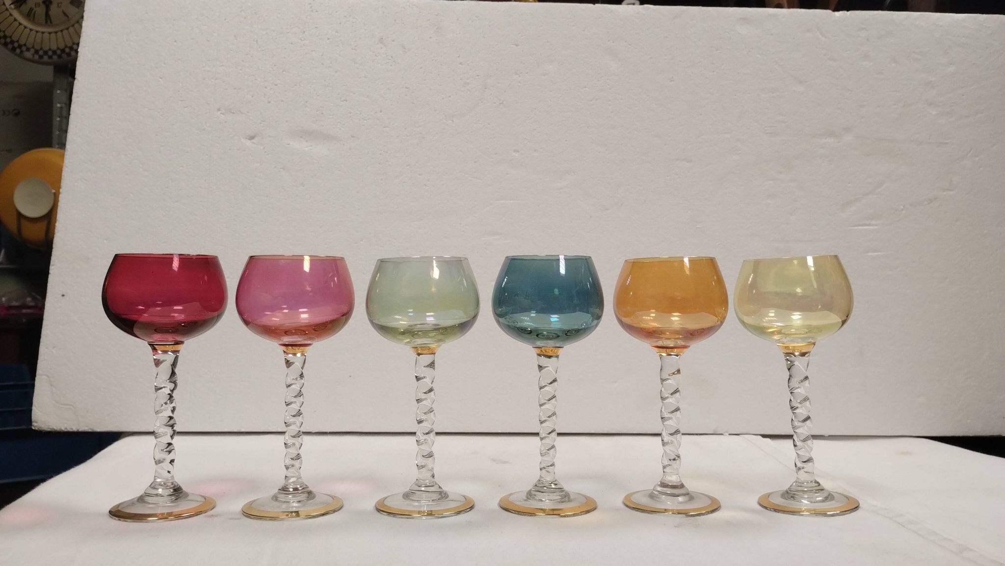 Set of 6 colored crystal stemmed glasses with gold twisted foot.