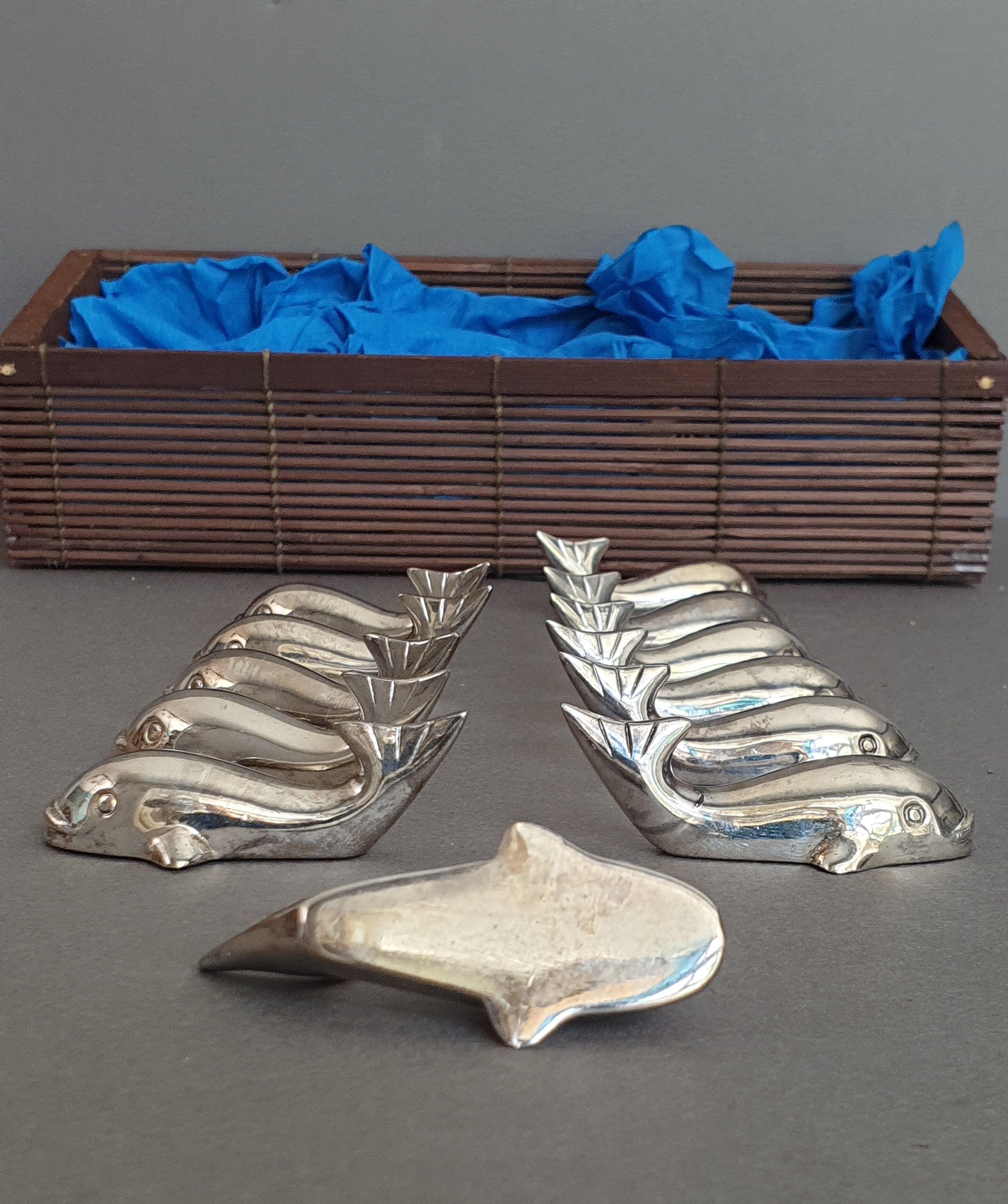 Lot 12 knife holders in the shape of a stylized whale or fish