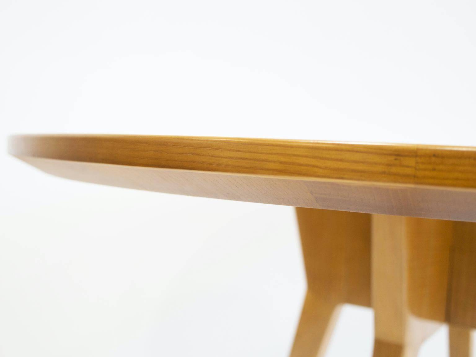 Round dining table in Wood Wood with brass details.