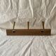 Vintage wooden wall-mounted coat rack with 3 golden cast aluminum hooks