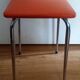 Tabouret orange pieds compas