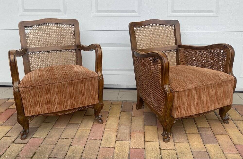Pair of 1920s brown armchairs in carved wood and fabric, with caning detail.