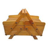 Little worker sewing old wooden table